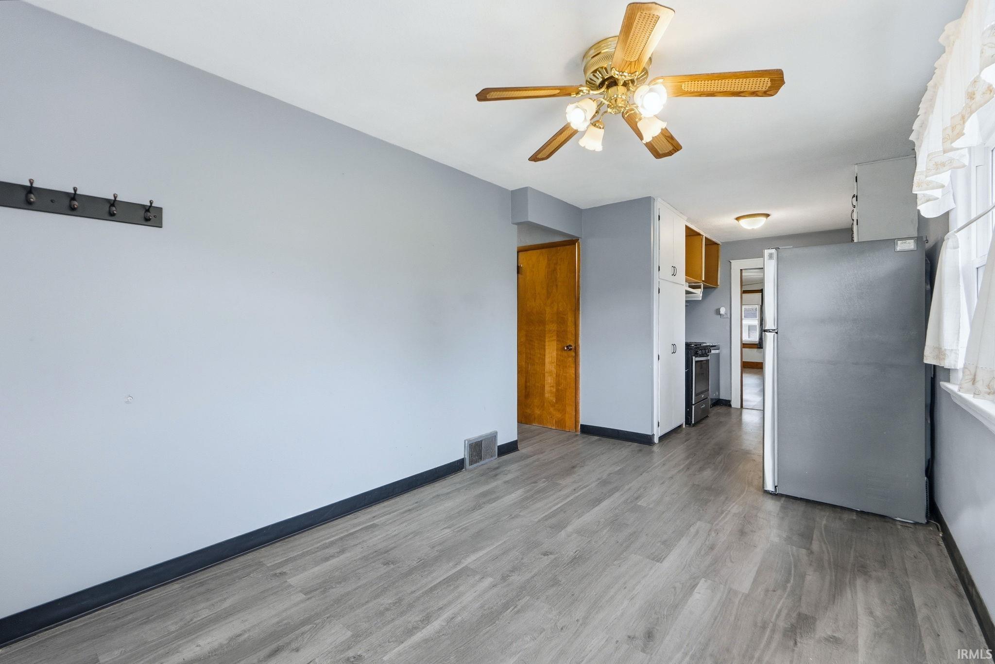 Unfurnished living room featuring a ceiling fan and light wood finished floors