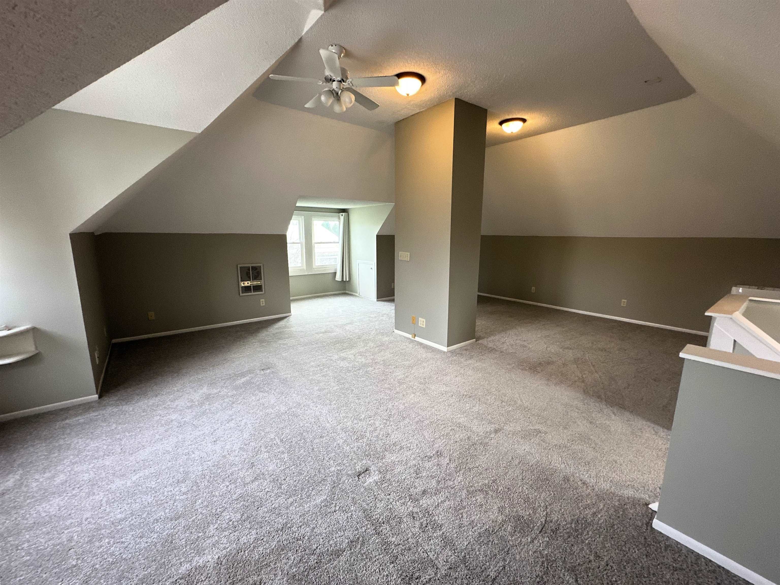Additional living space featuring ceiling fan and carpet