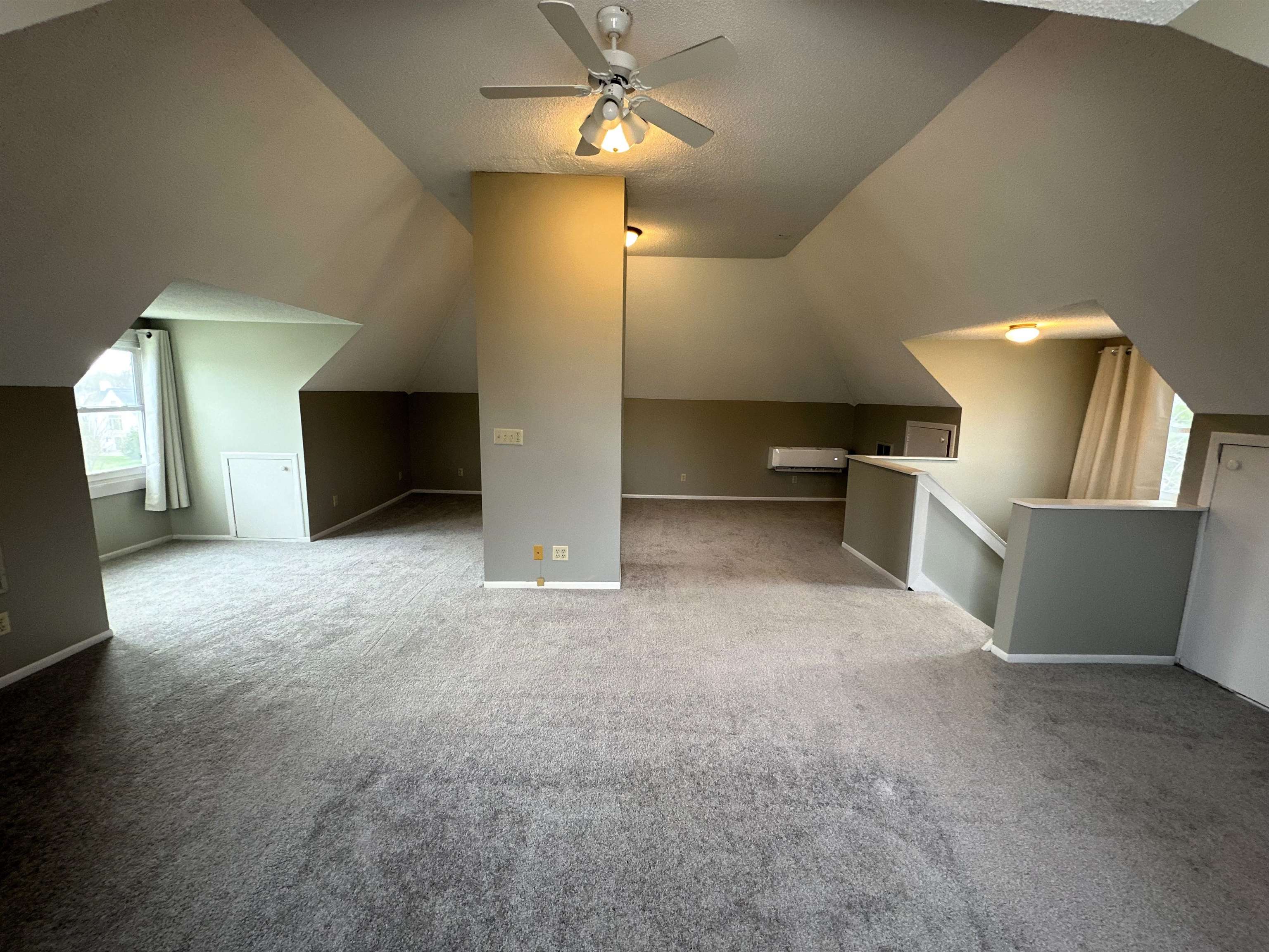 Bonus room with plenty of natural light, ceiling fan, and carpet