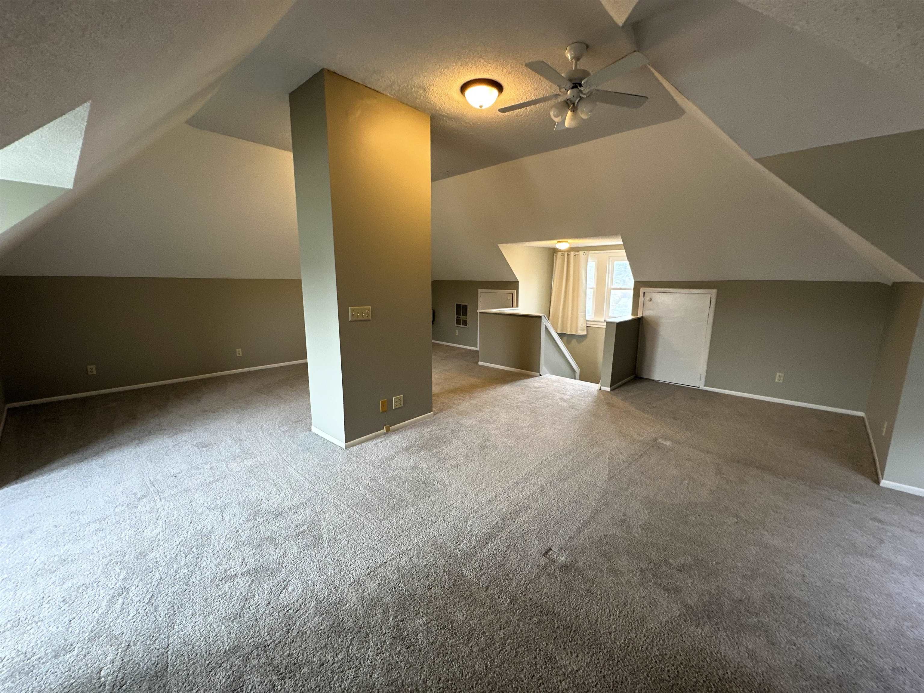 Bonus room with carpet flooring, ceiling fan, and a skylight