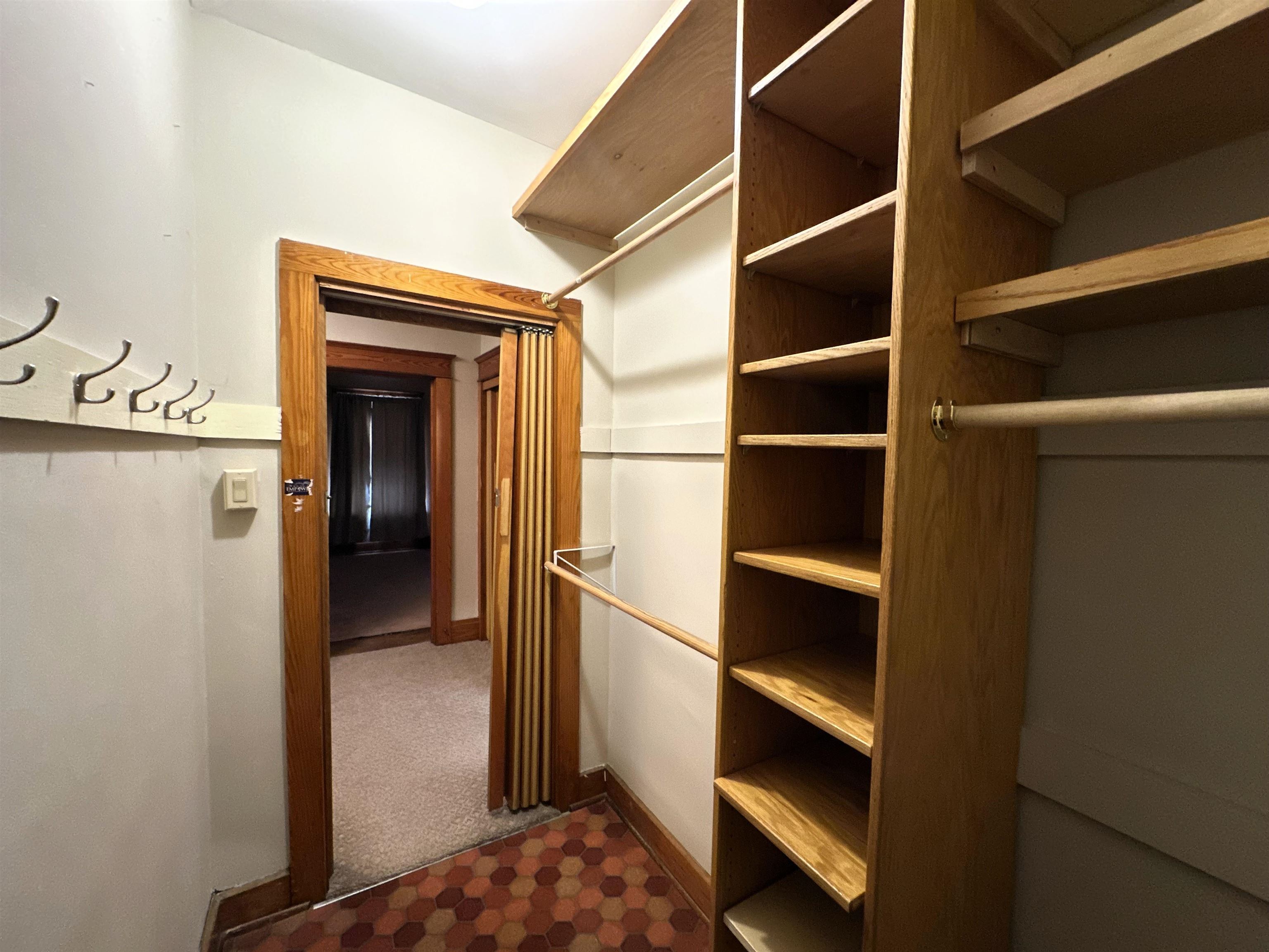 Walk in closet featuring dark carpet