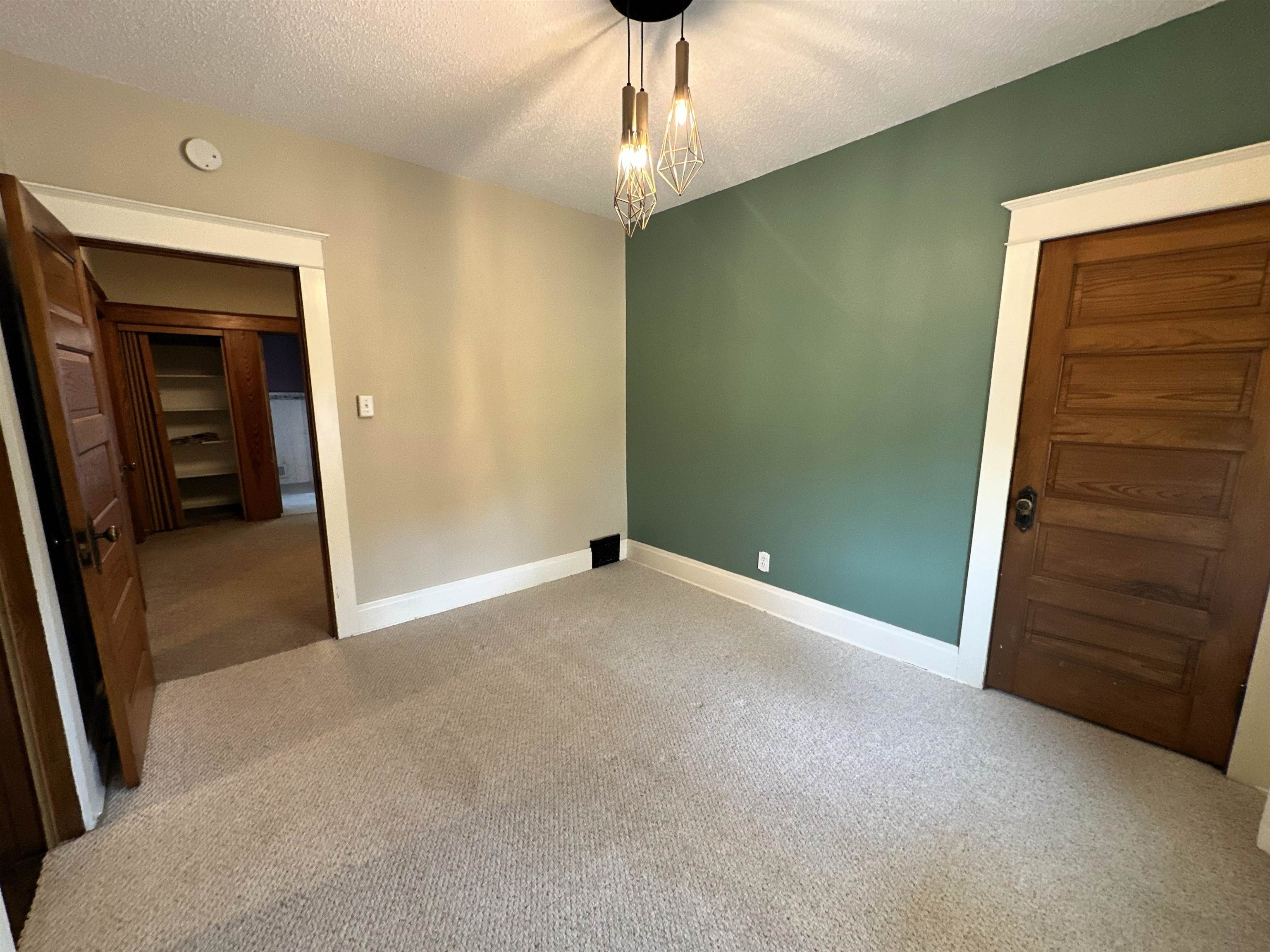 Carpeted spare room with baseboards and a textured ceiling