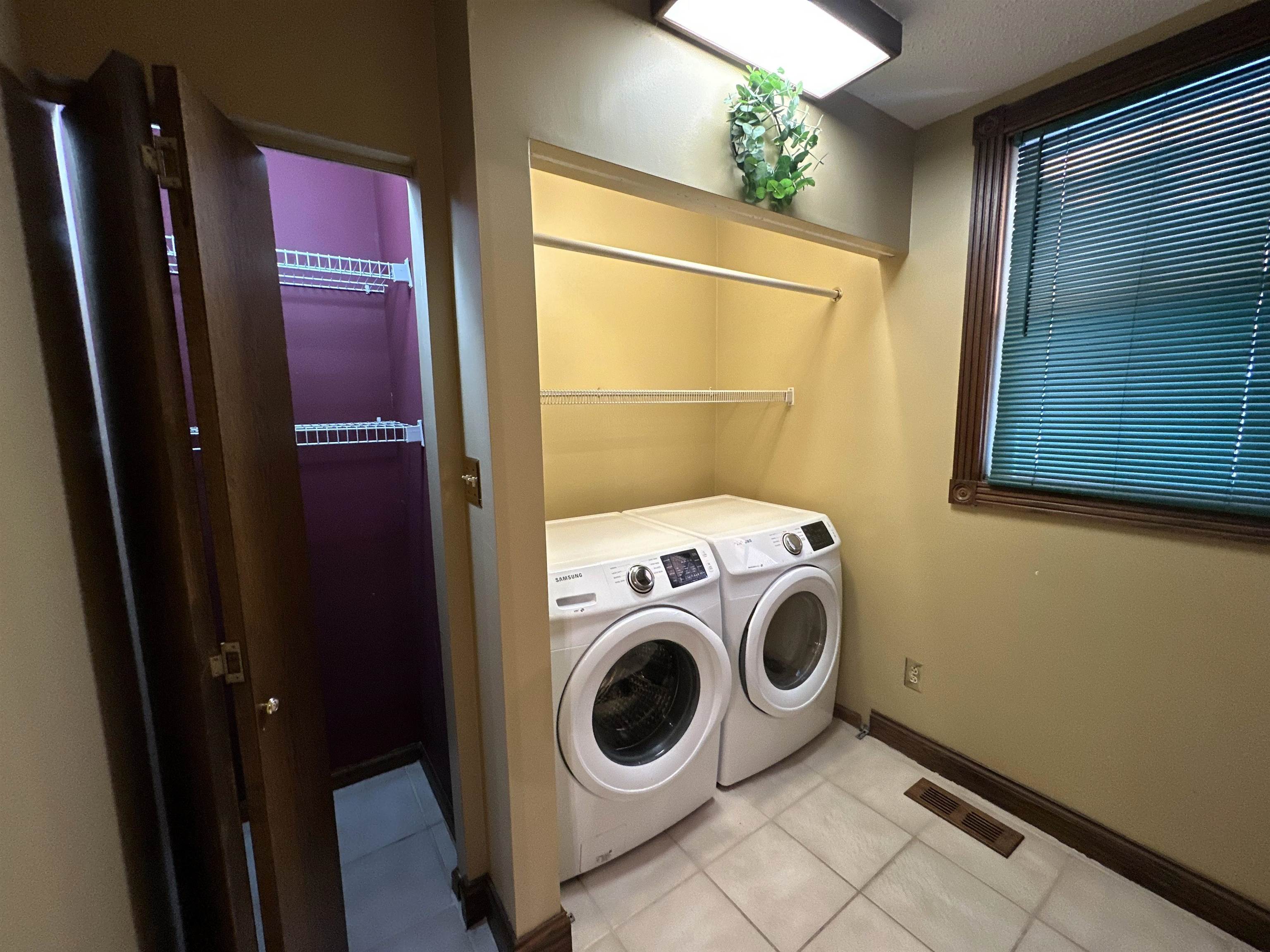 Laundry room featuring washing machine and clothes dryer and light tile patterned floors