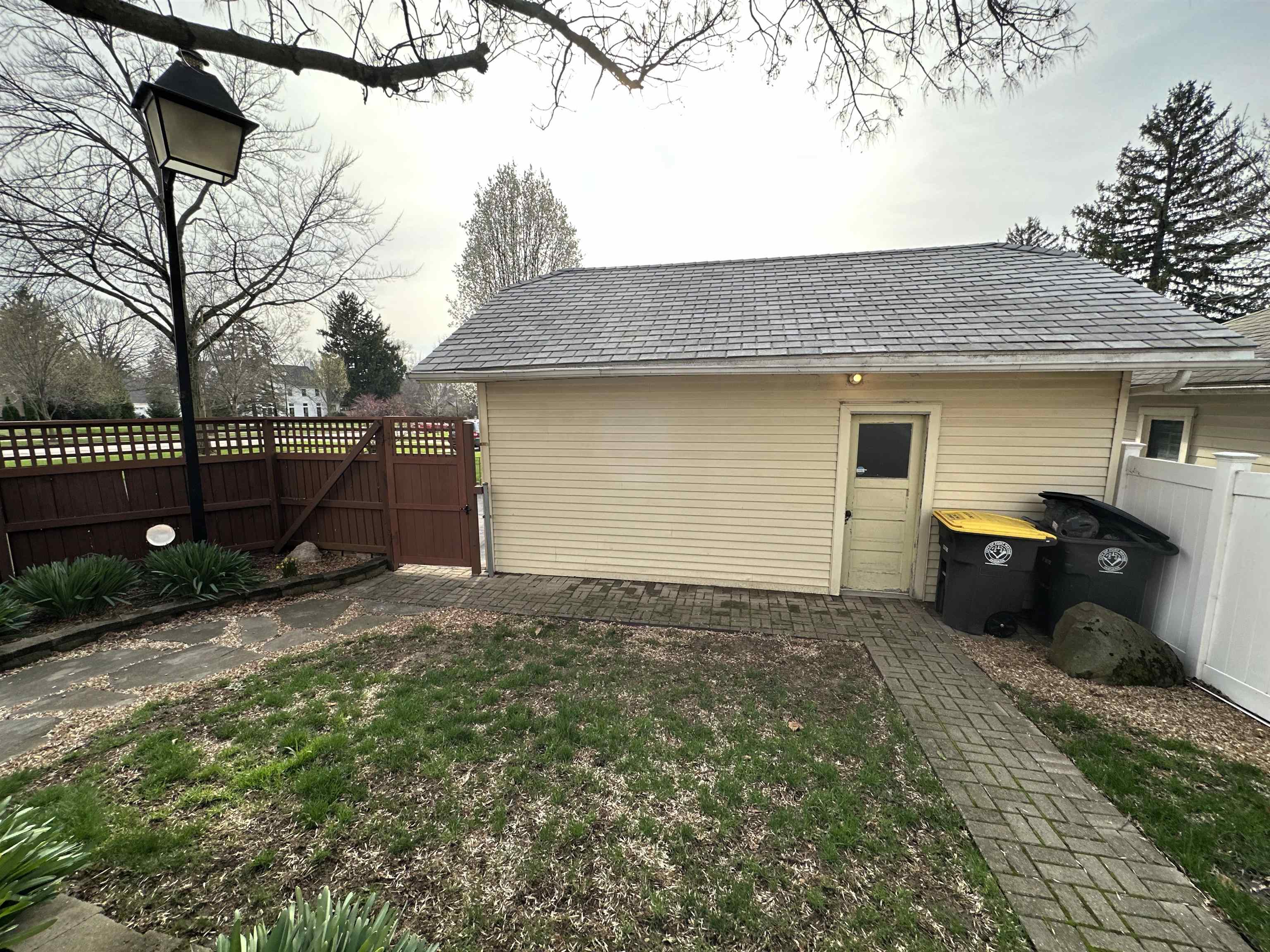 View of outbuilding with a fenced backyard and a gate