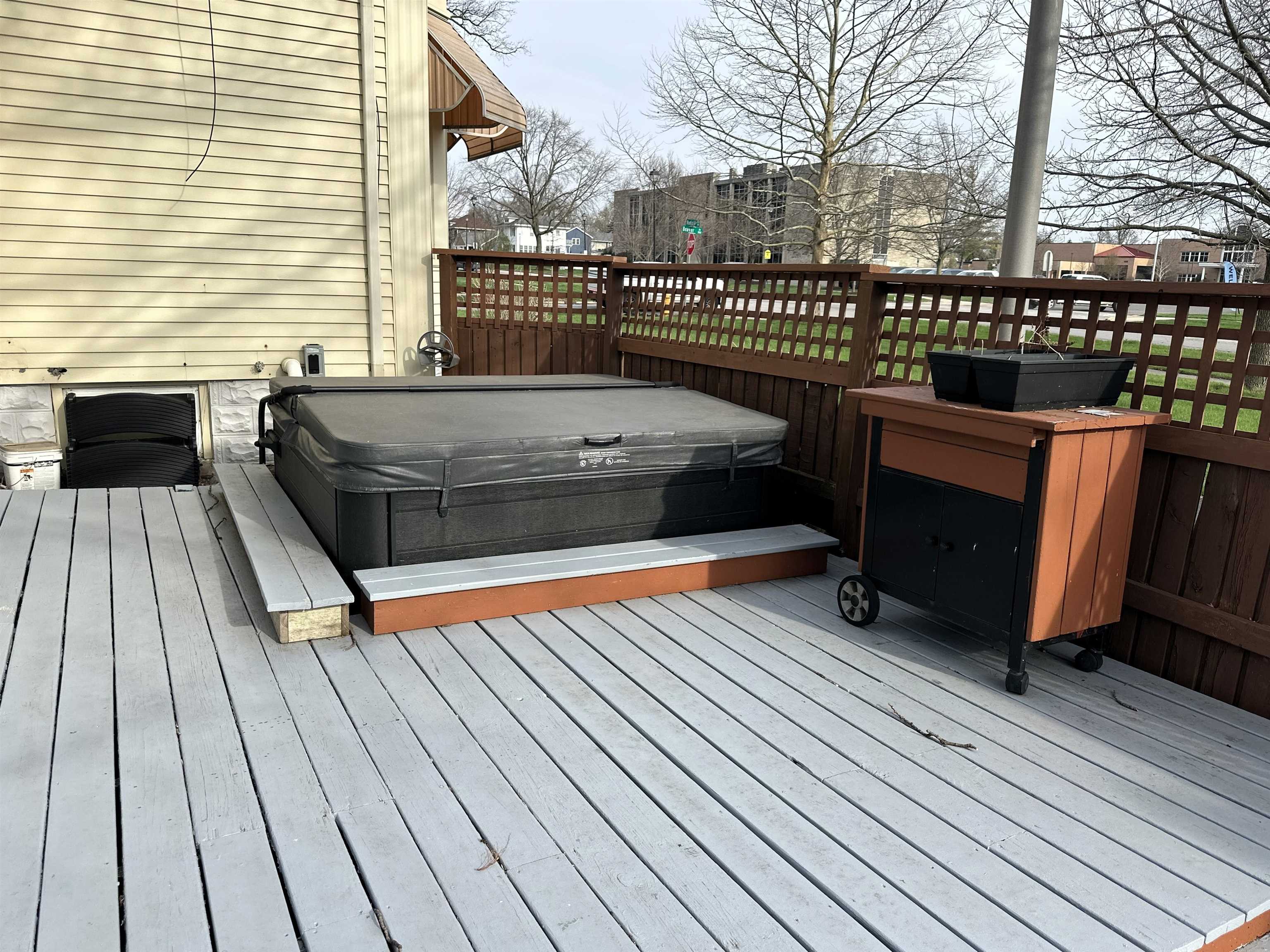 Wooden terrace with a covered hot tub