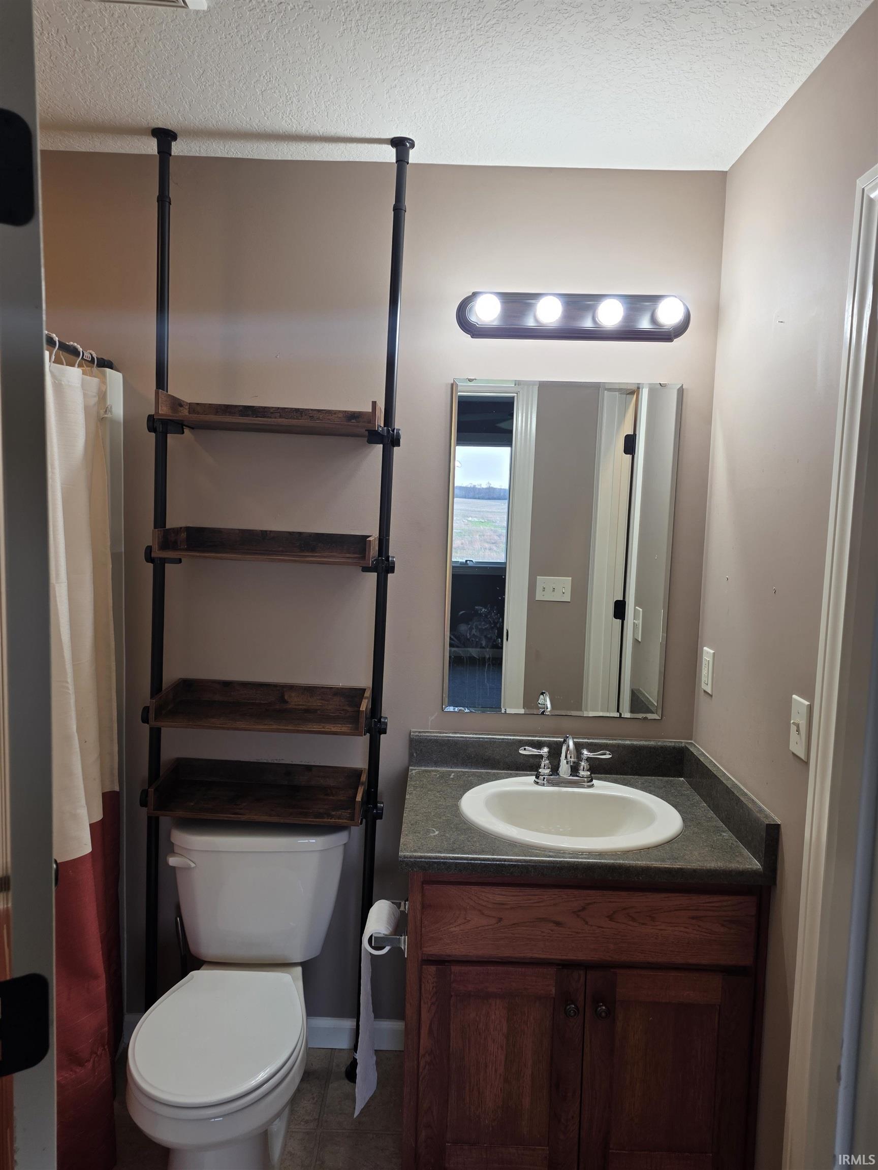 Bathroom featuring vanity, a textured ceiling, and a shower with shower curtain