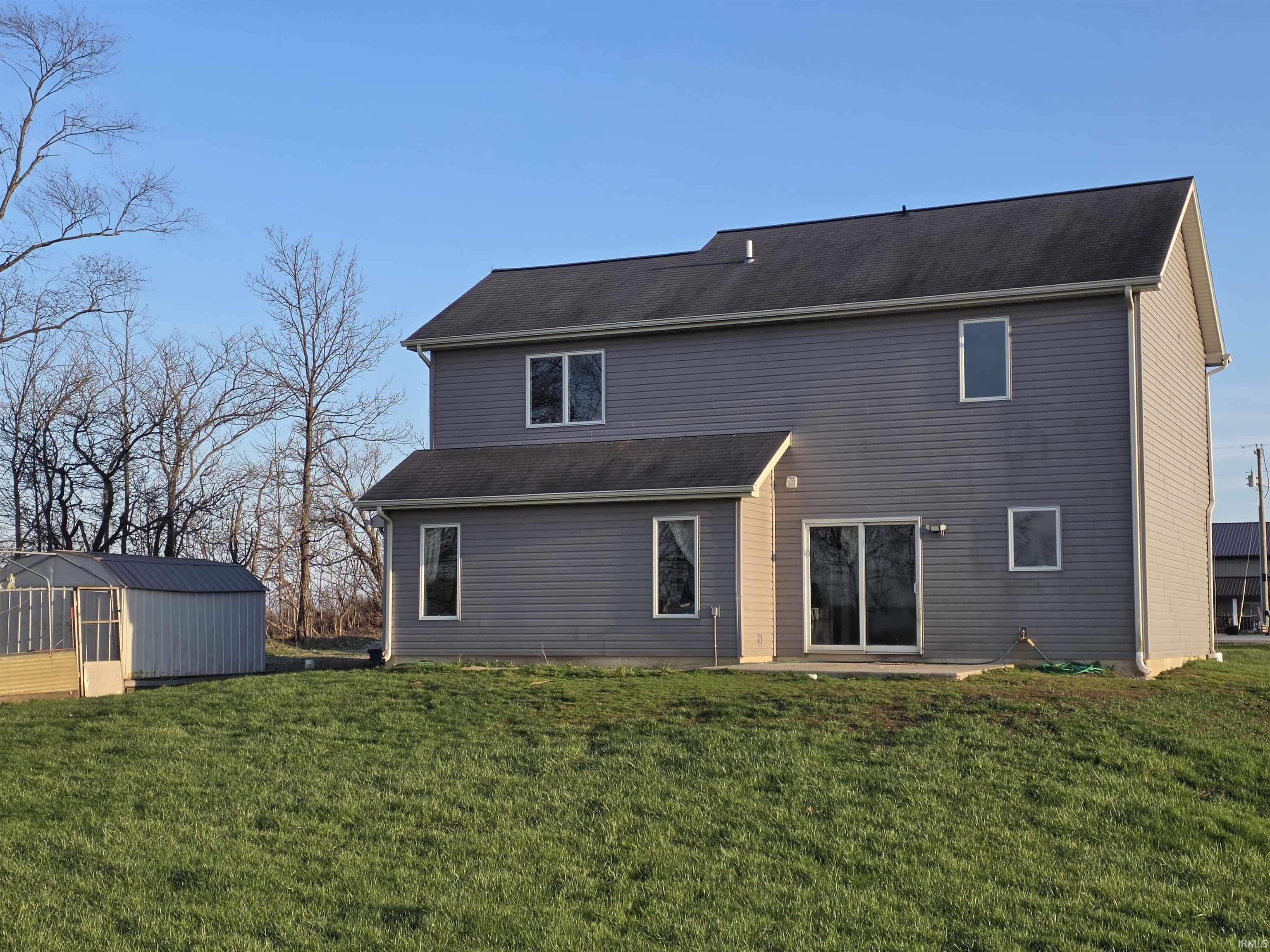 Back of property with a yard and an outdoor structure