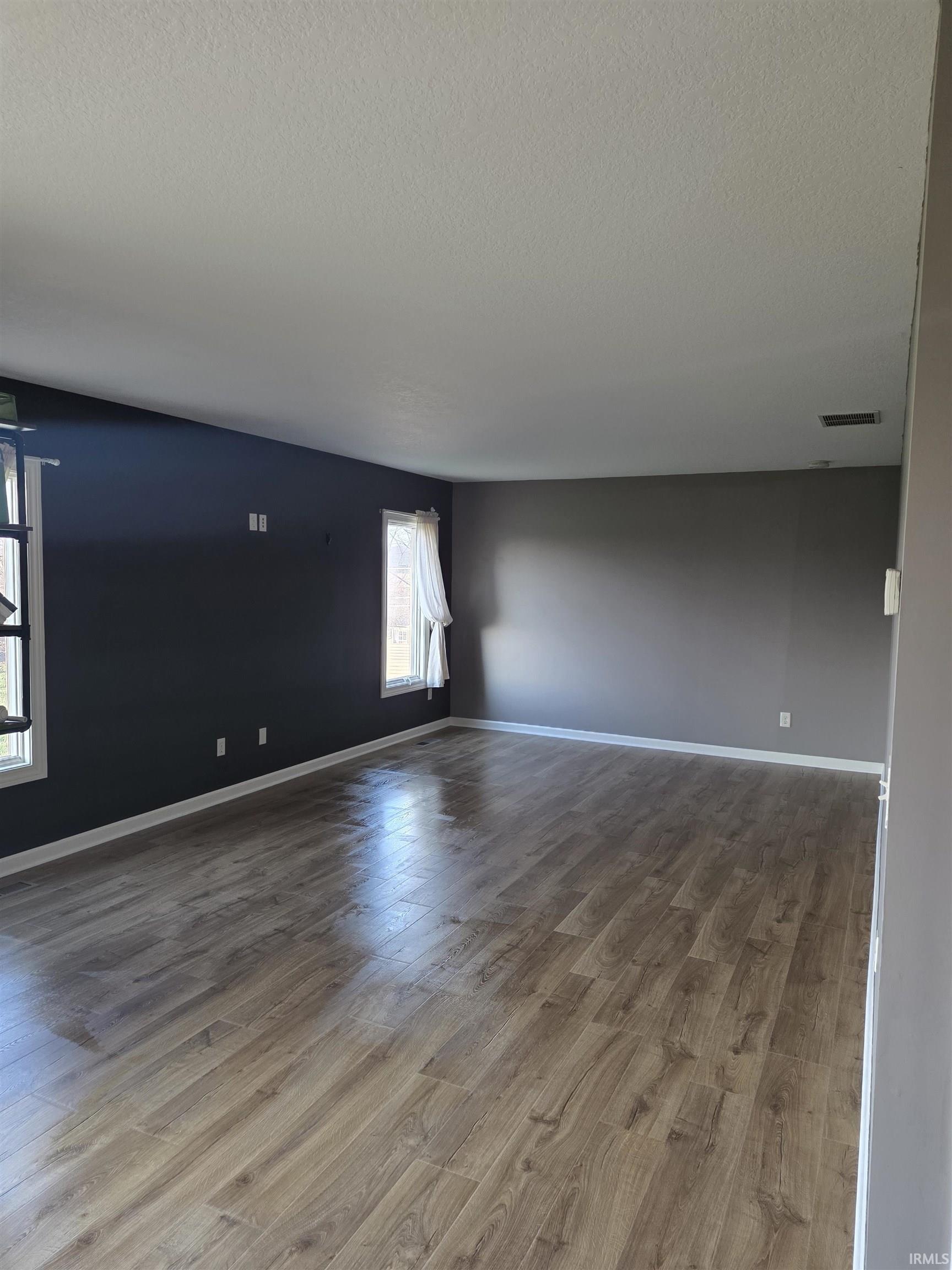 Unfurnished room with dark wood-style floors and a textured ceiling