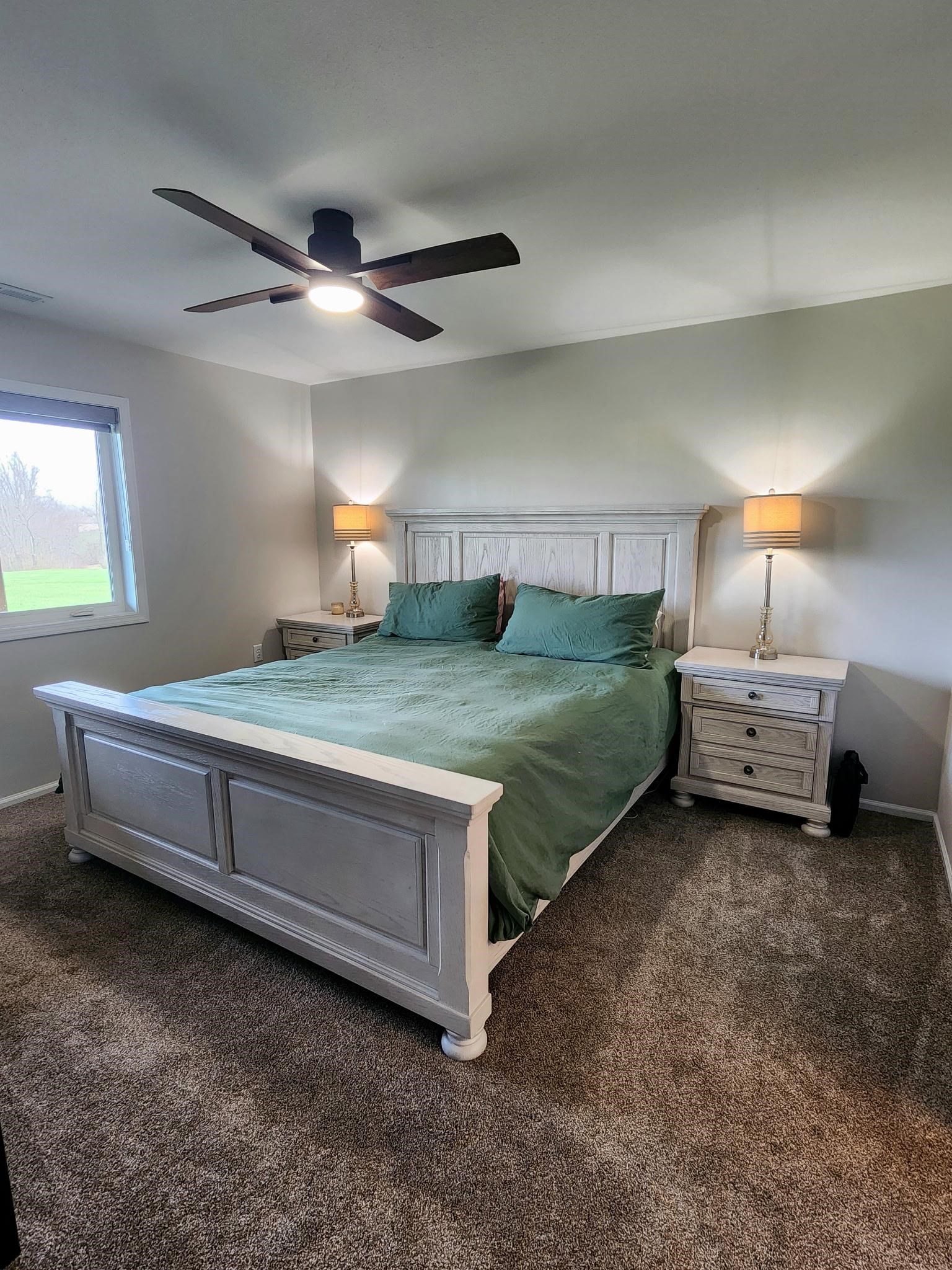 Bedroom featuring dark carpet and a ceiling fan