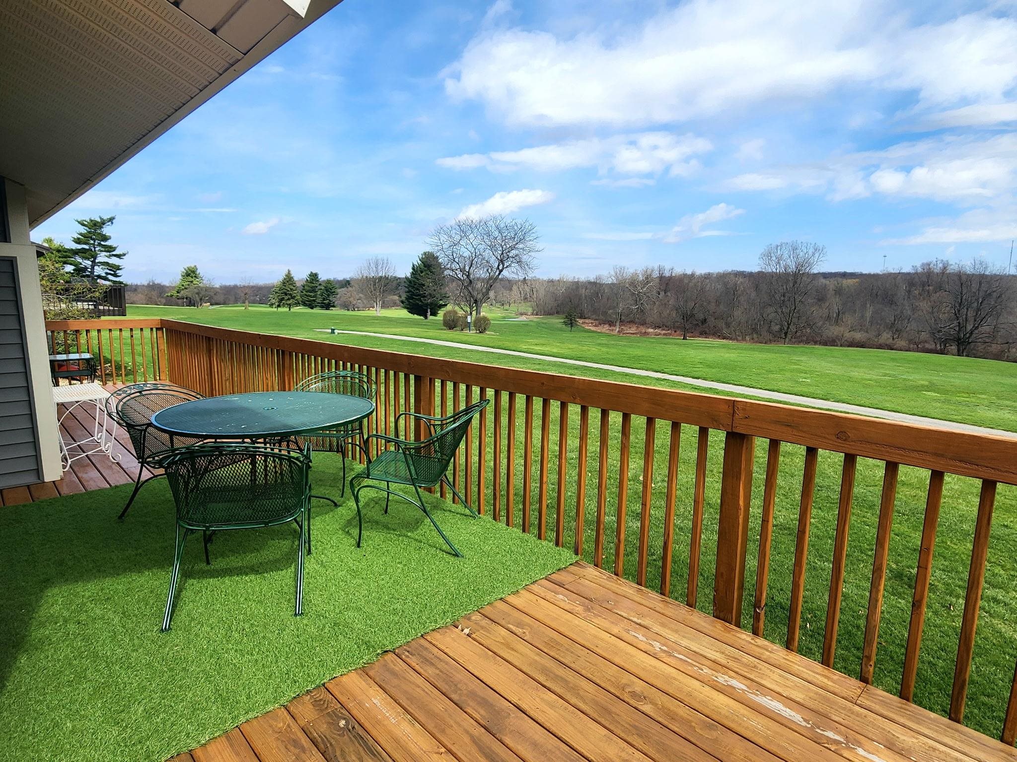 Wooden terrace featuring outdoor dining space and a lawn