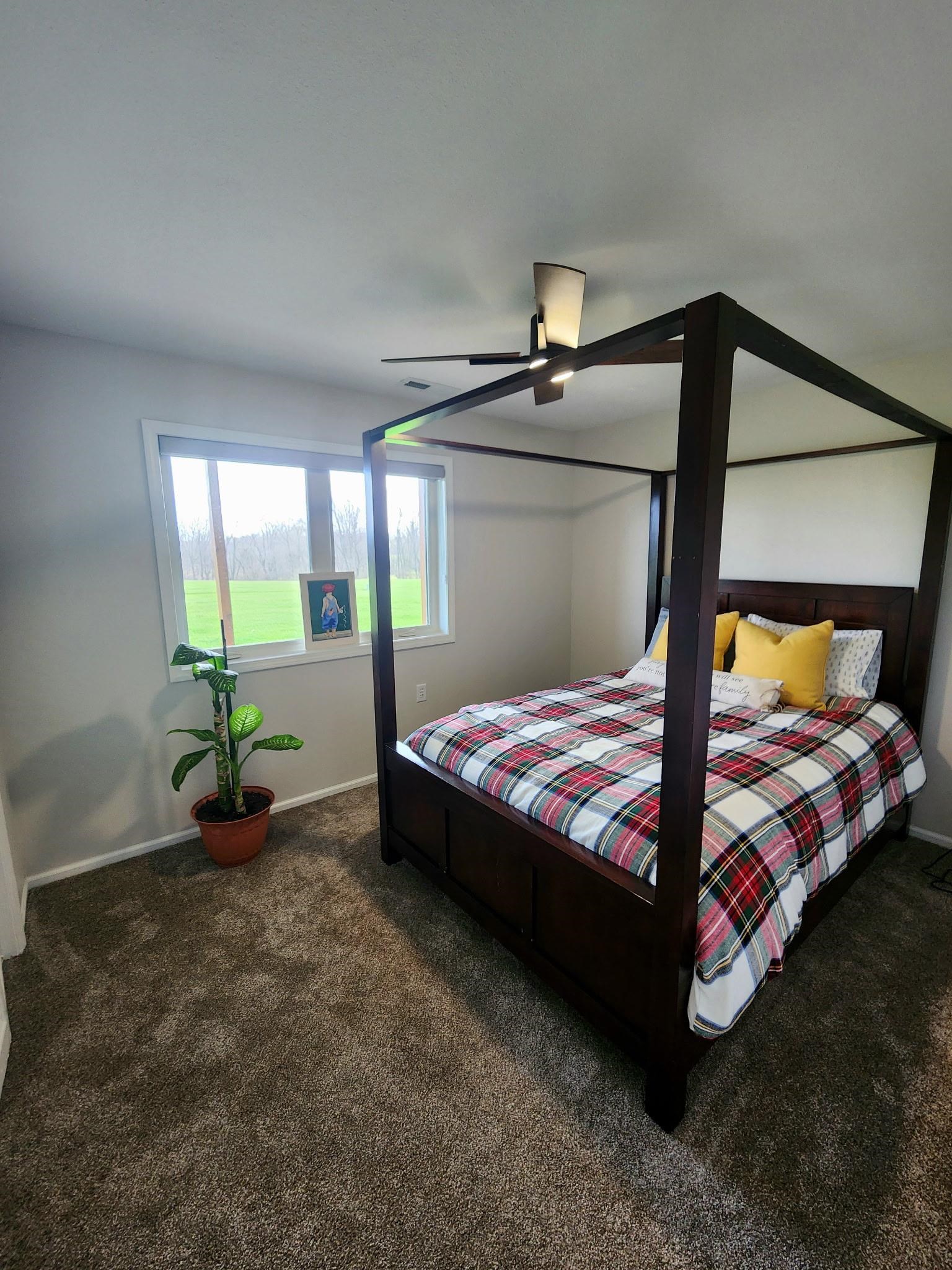 Bedroom with dark carpet and ceiling fan