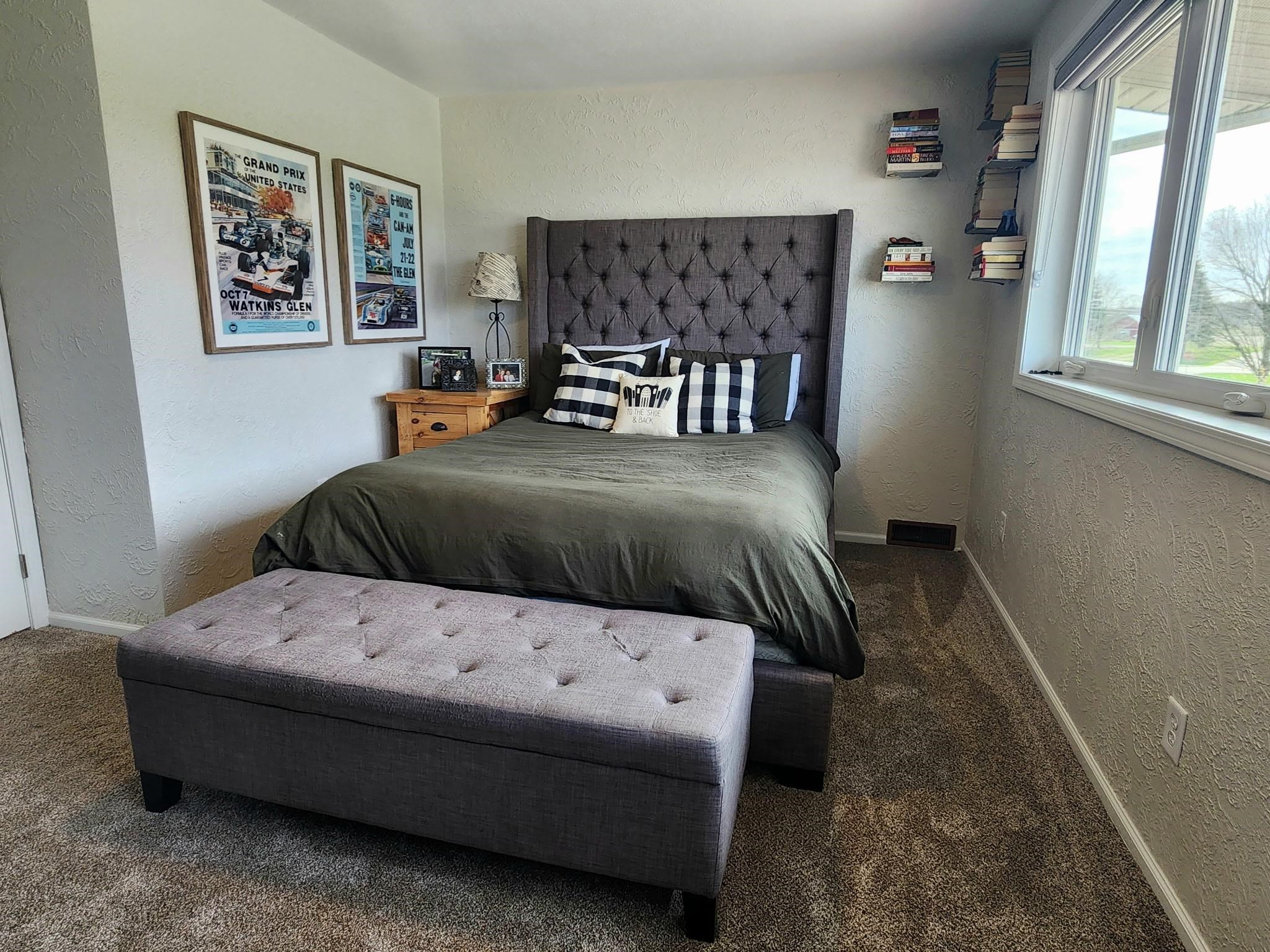Carpeted bedroom featuring a textured wall and baseboards