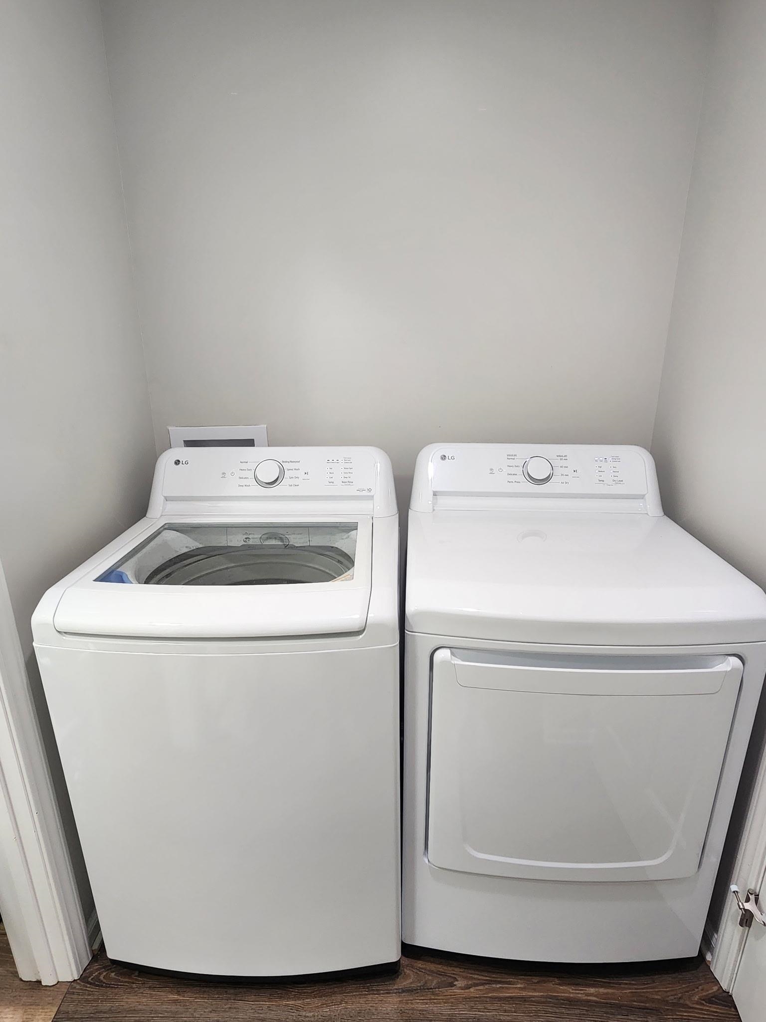 Laundry area featuring washer and clothes dryer and dark wood finished floors