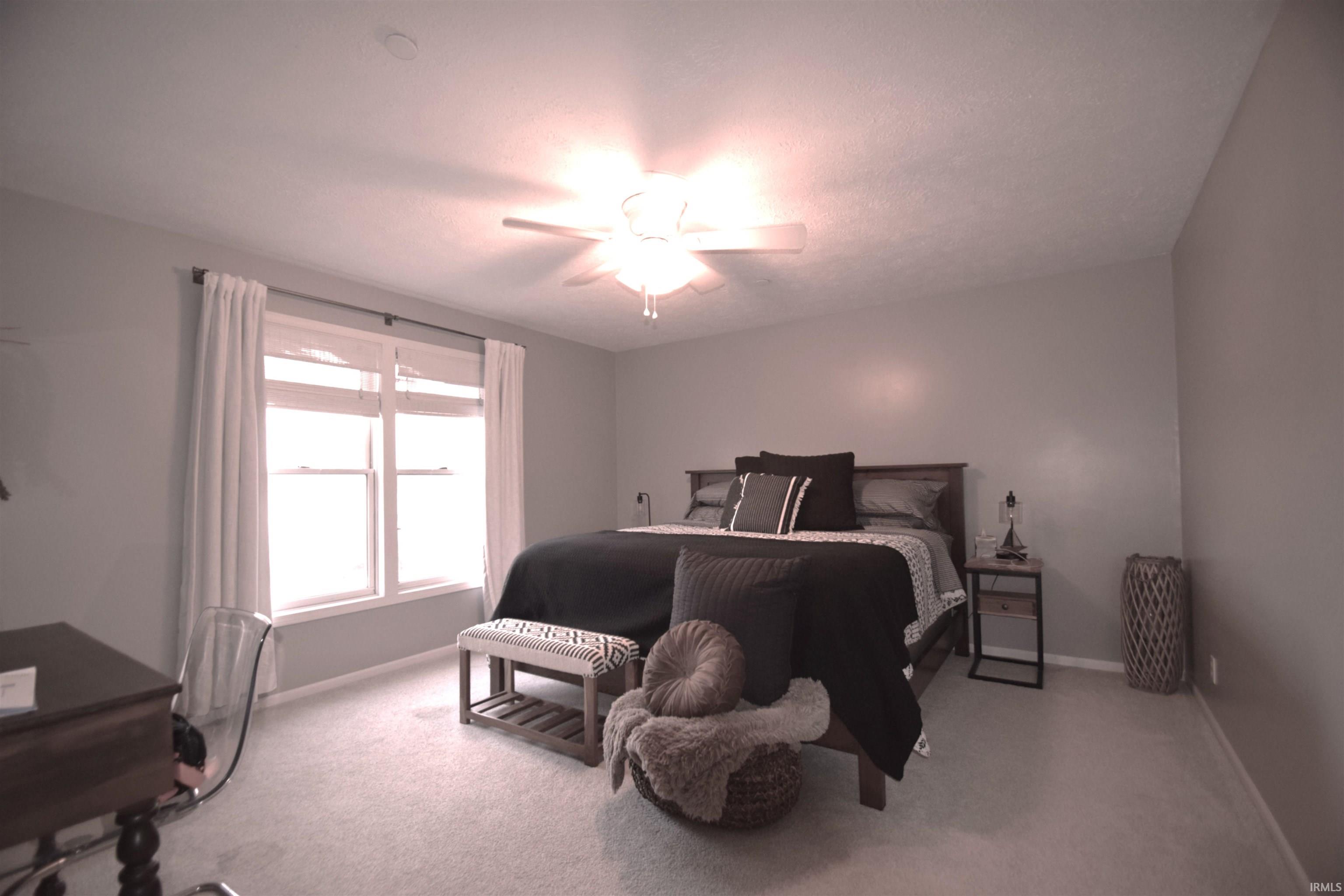 Bedroom featuring light colored carpet and ceiling fan