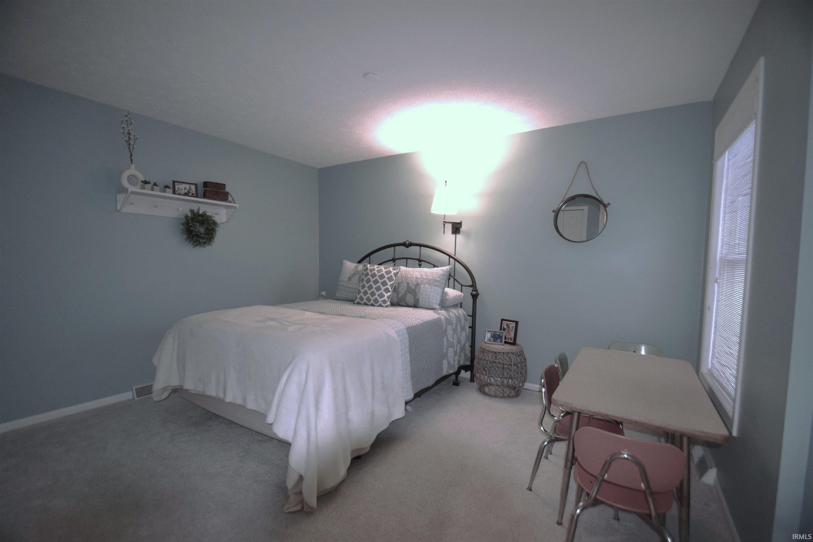 Bedroom featuring light carpet and baseboards