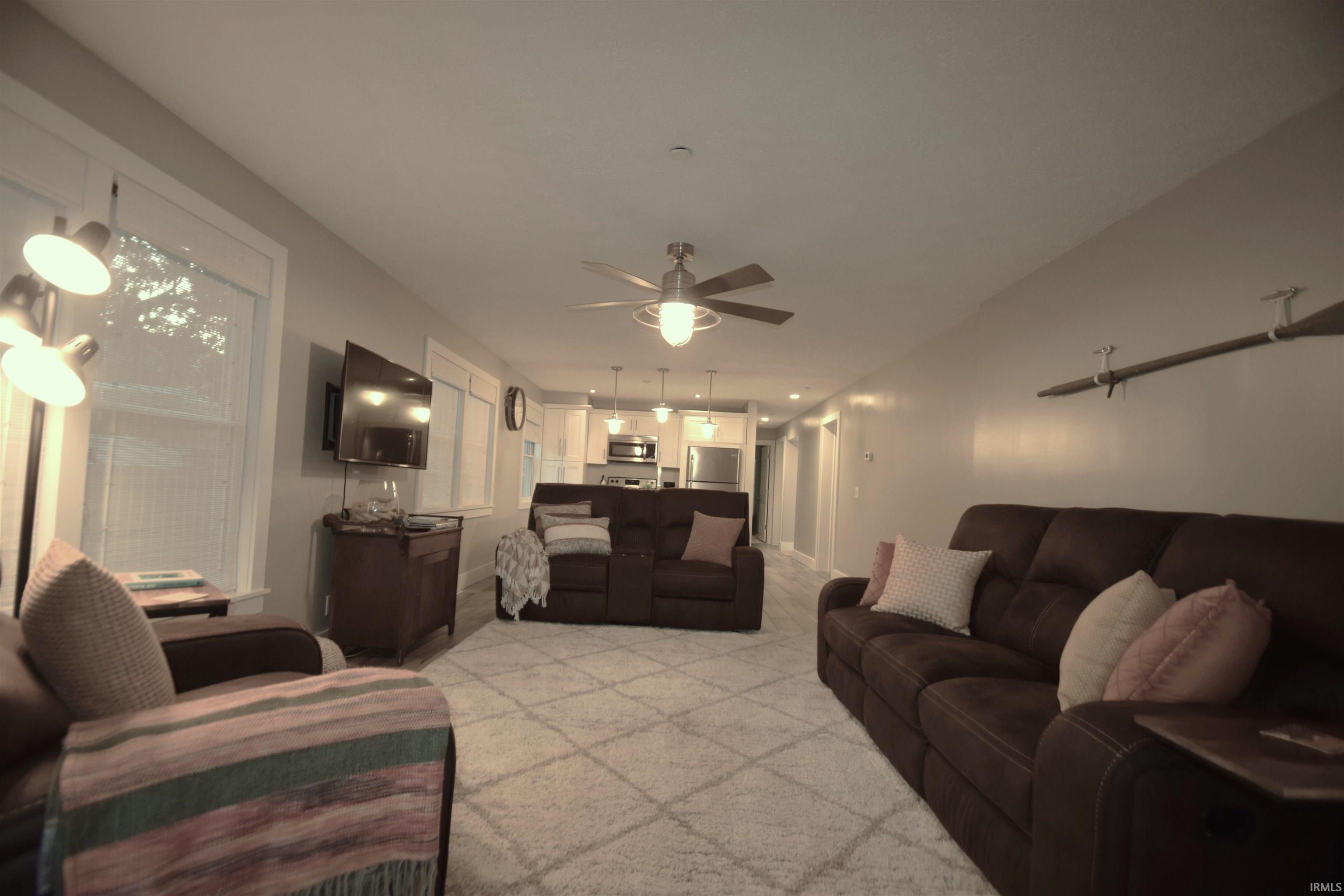 Living room featuring a ceiling fan and light colored carpet