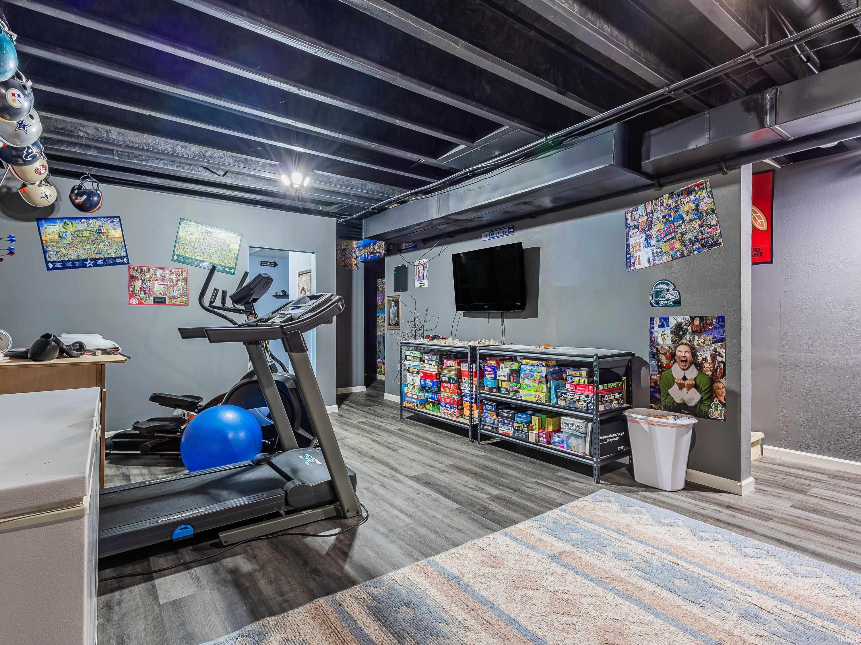 Workout room with light wood-style flooring and baseboards