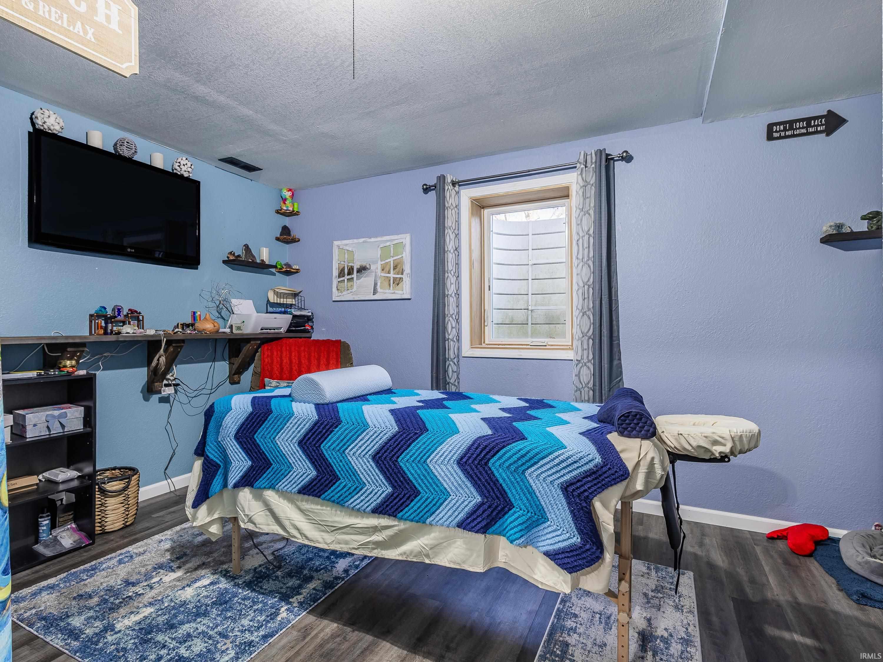 Bedroom featuring a textured ceiling and dark wood-style floors