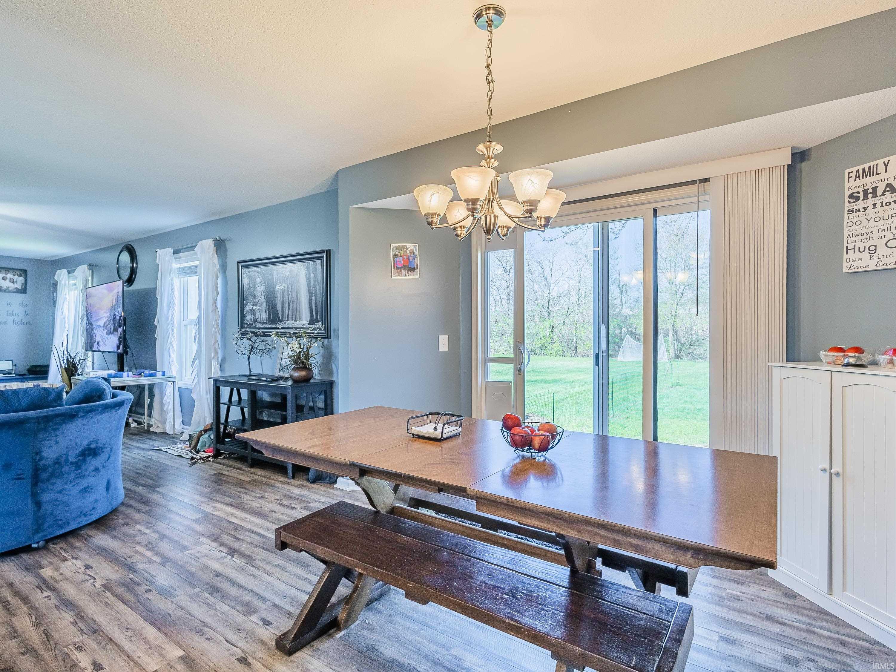 Dining room with suspended lighting and wood finished floors
