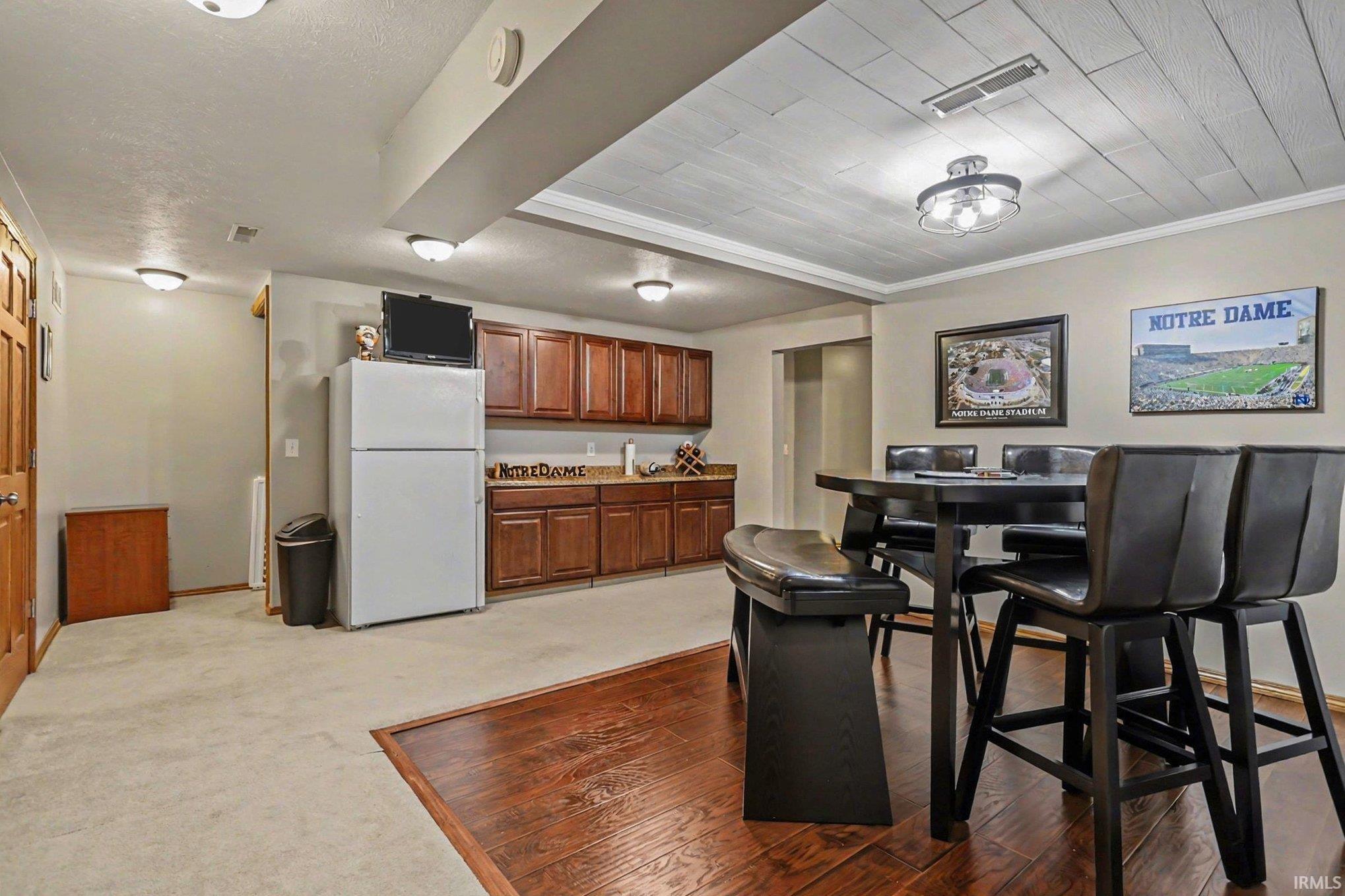 Dining area with dark wood-style flooring and dark carpet