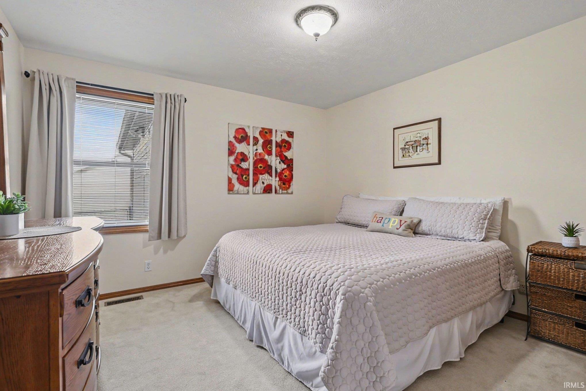 Bedroom featuring light carpet and baseboards