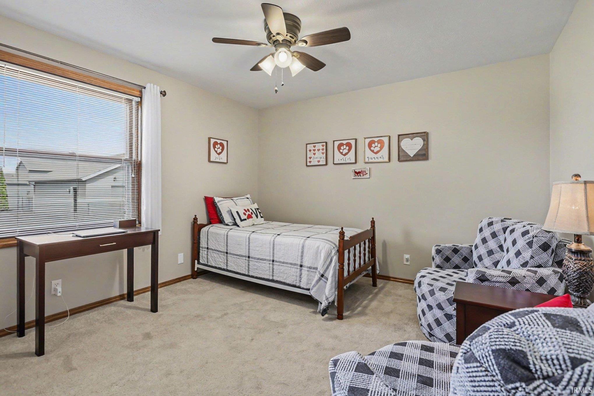 Bedroom with light colored carpet and a ceiling fan