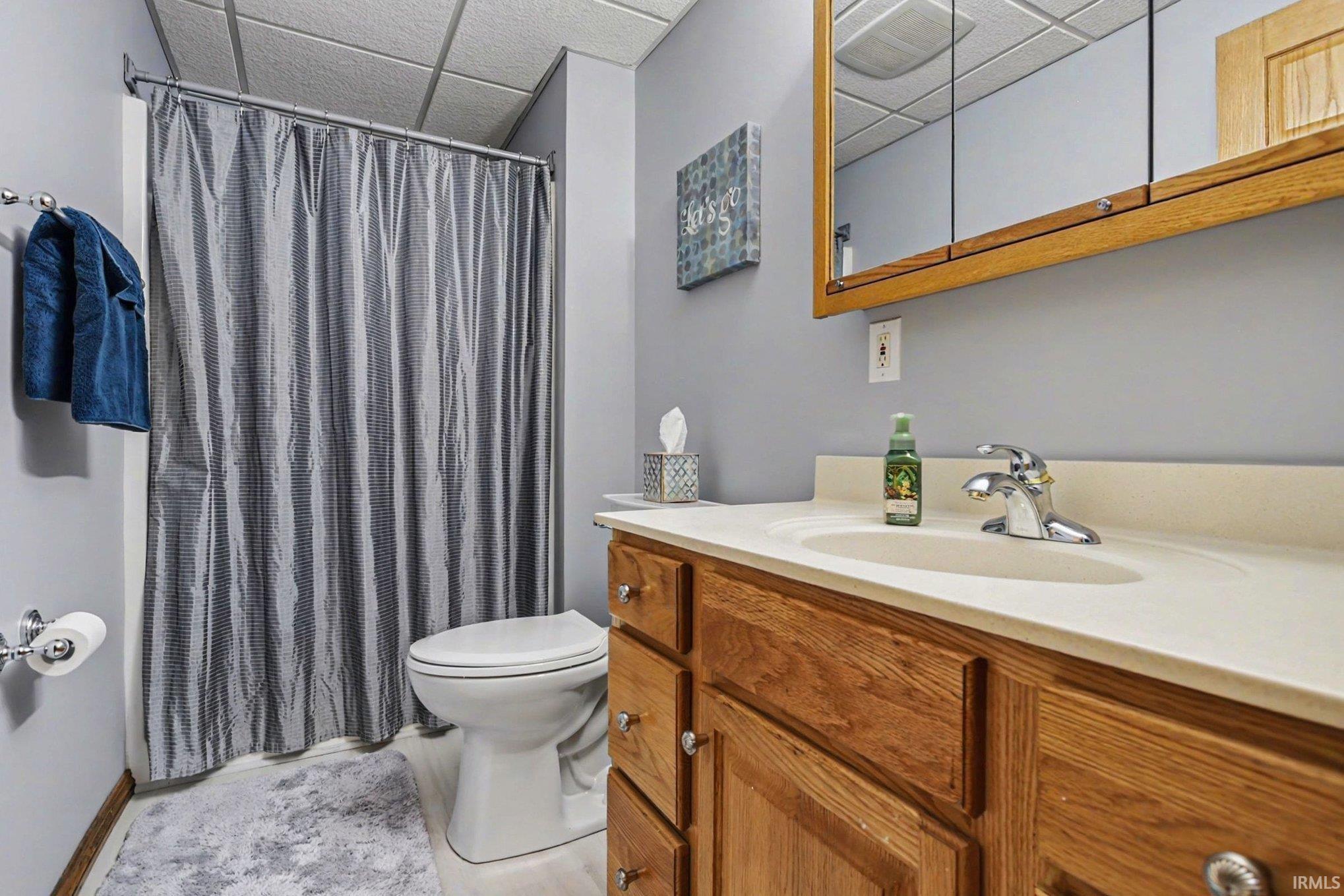 Full bathroom with vanity, a paneled ceiling, and a shower with shower curtain