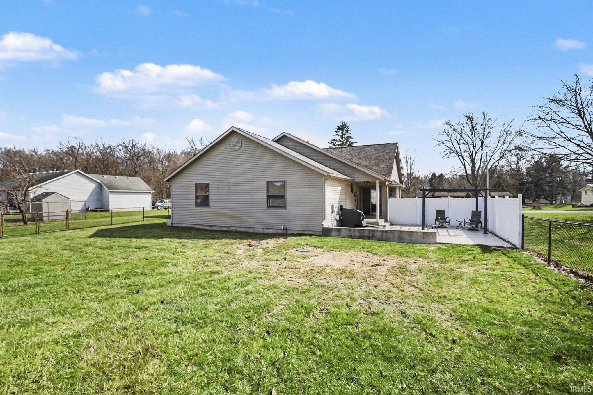 Rear view of house featuring a fenced backyard and a patio