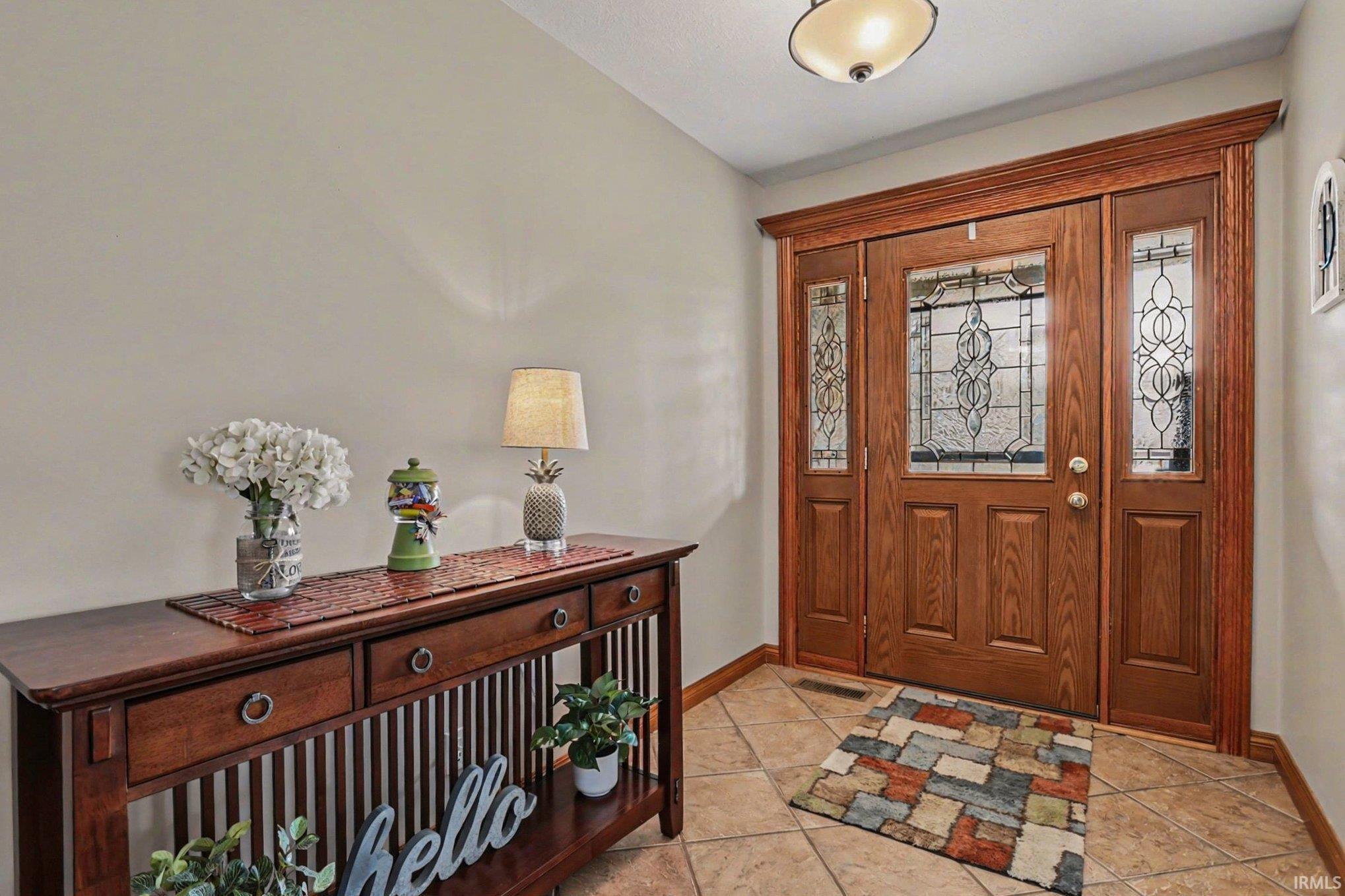 Foyer entrance featuring baseboards and light tile patterned floors