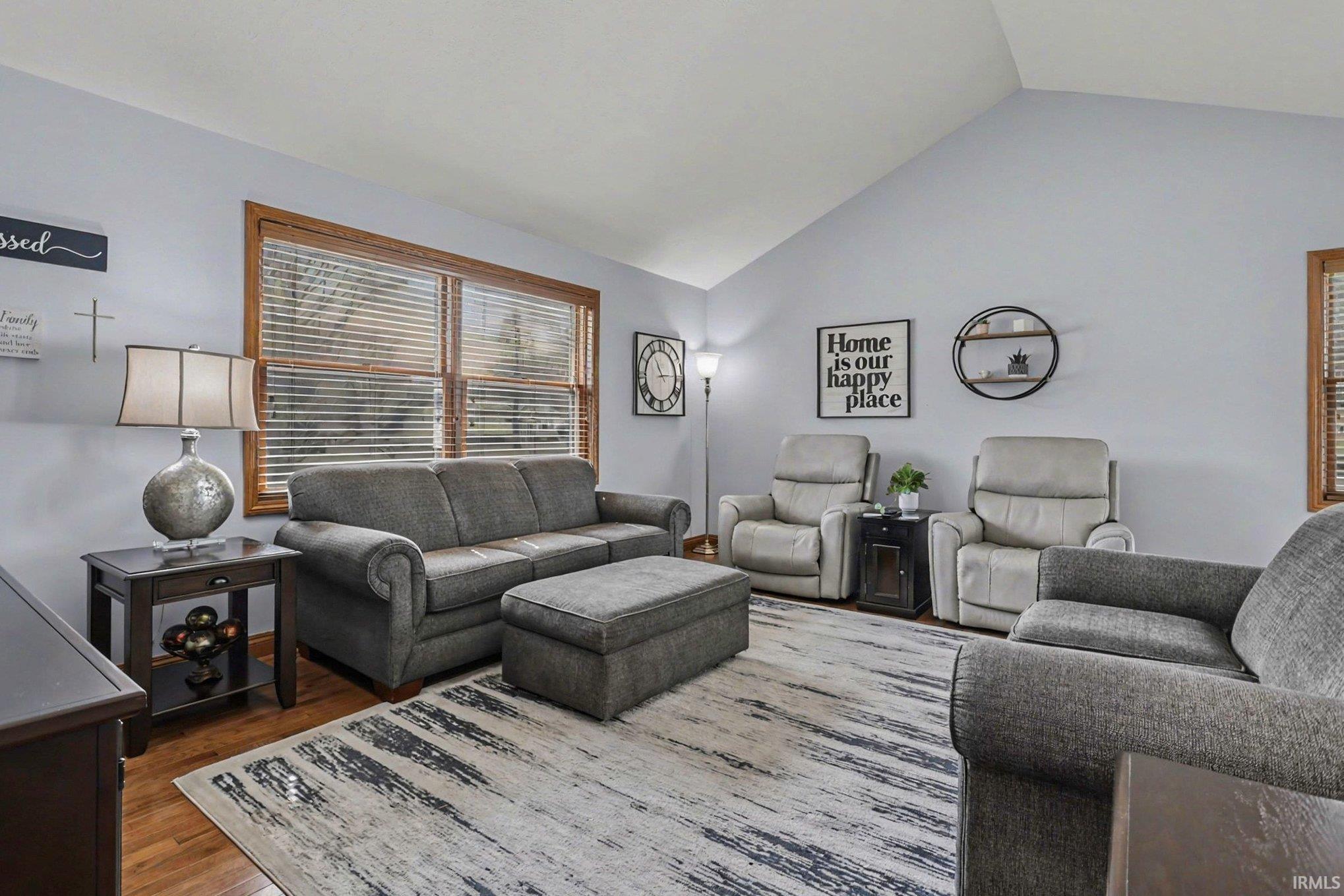 Living room with lofted ceiling and dark wood-style flooring