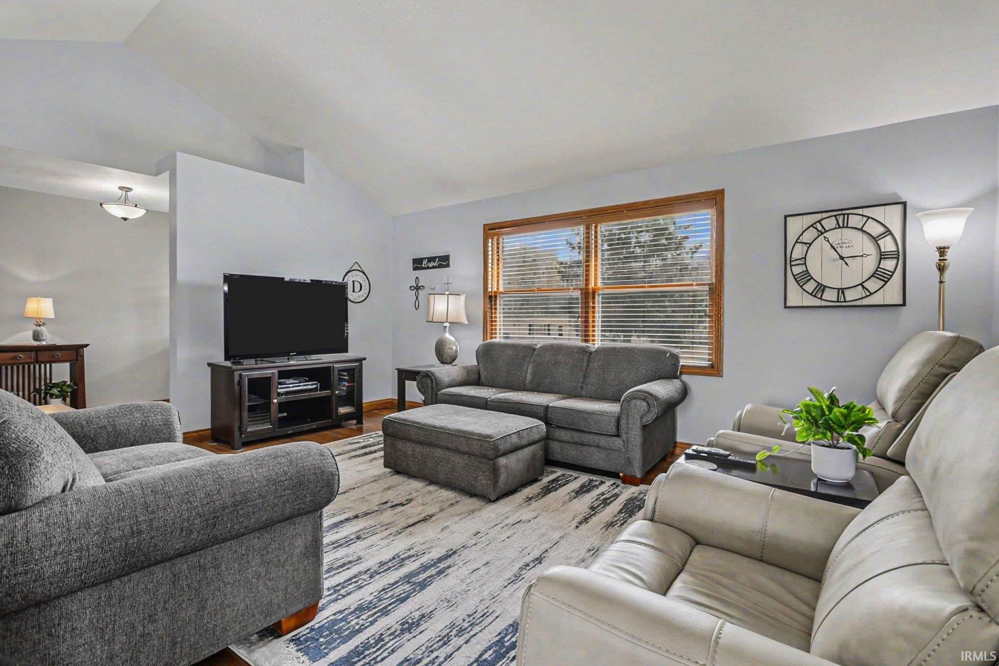 Living room with vaulted ceiling and wood finished floors