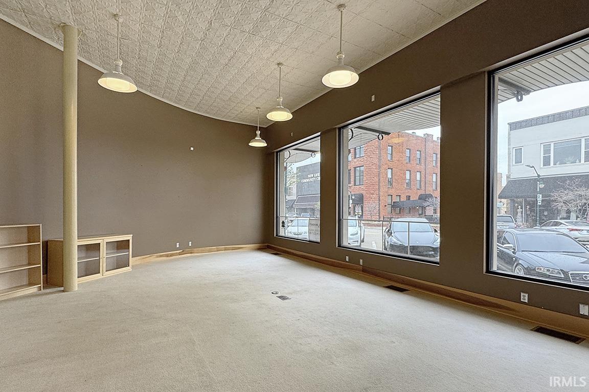 Carpeted spare room featuring baseboards