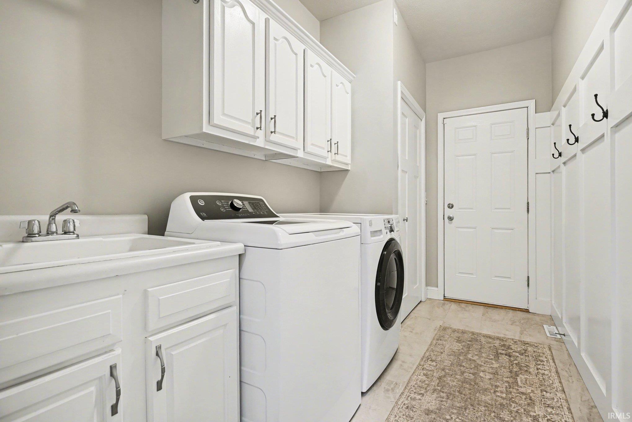 Laundry room featuring cabinet space and washer and clothes dryer