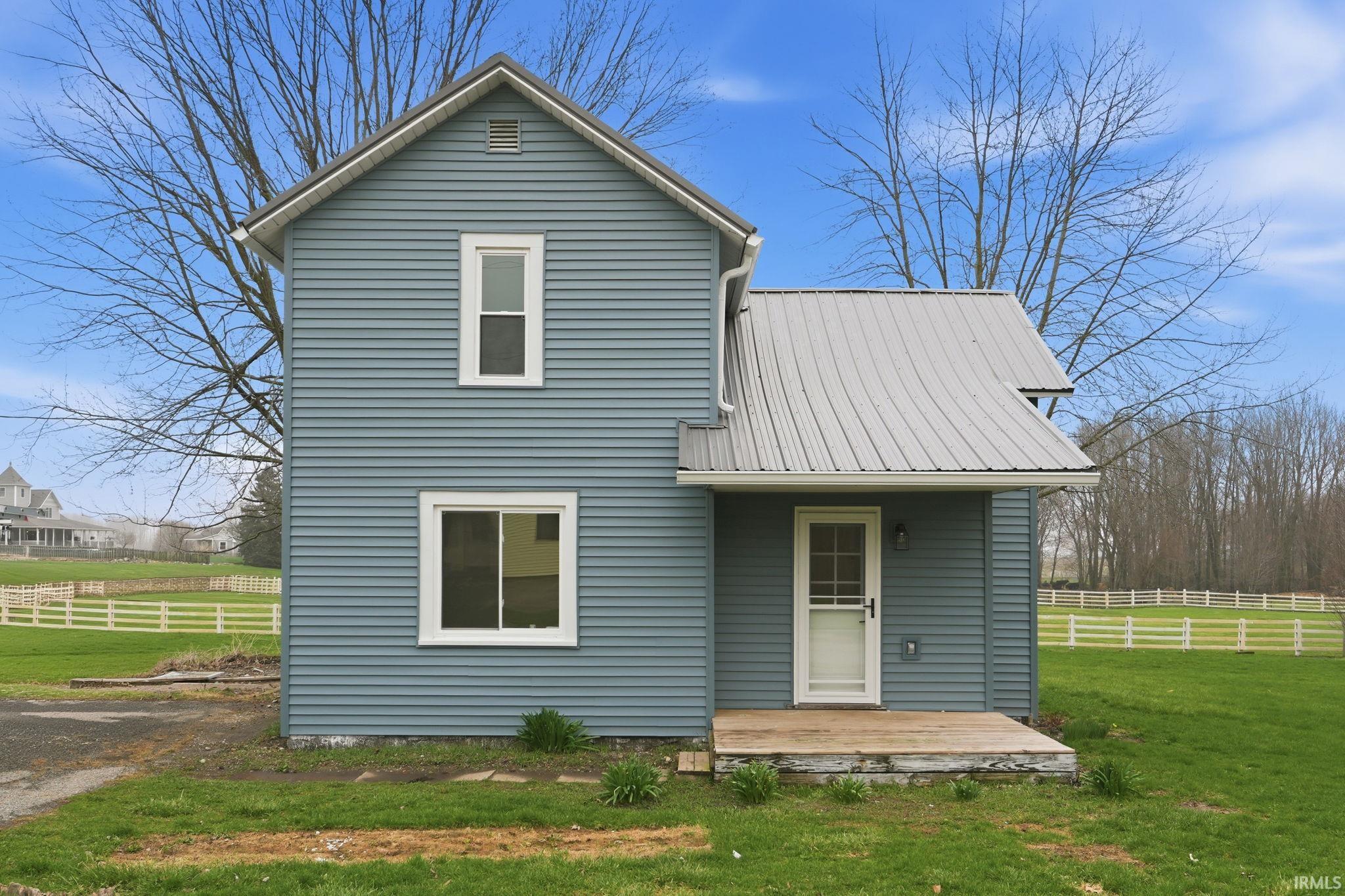 Rear view of house featuring a deck and a metal roof