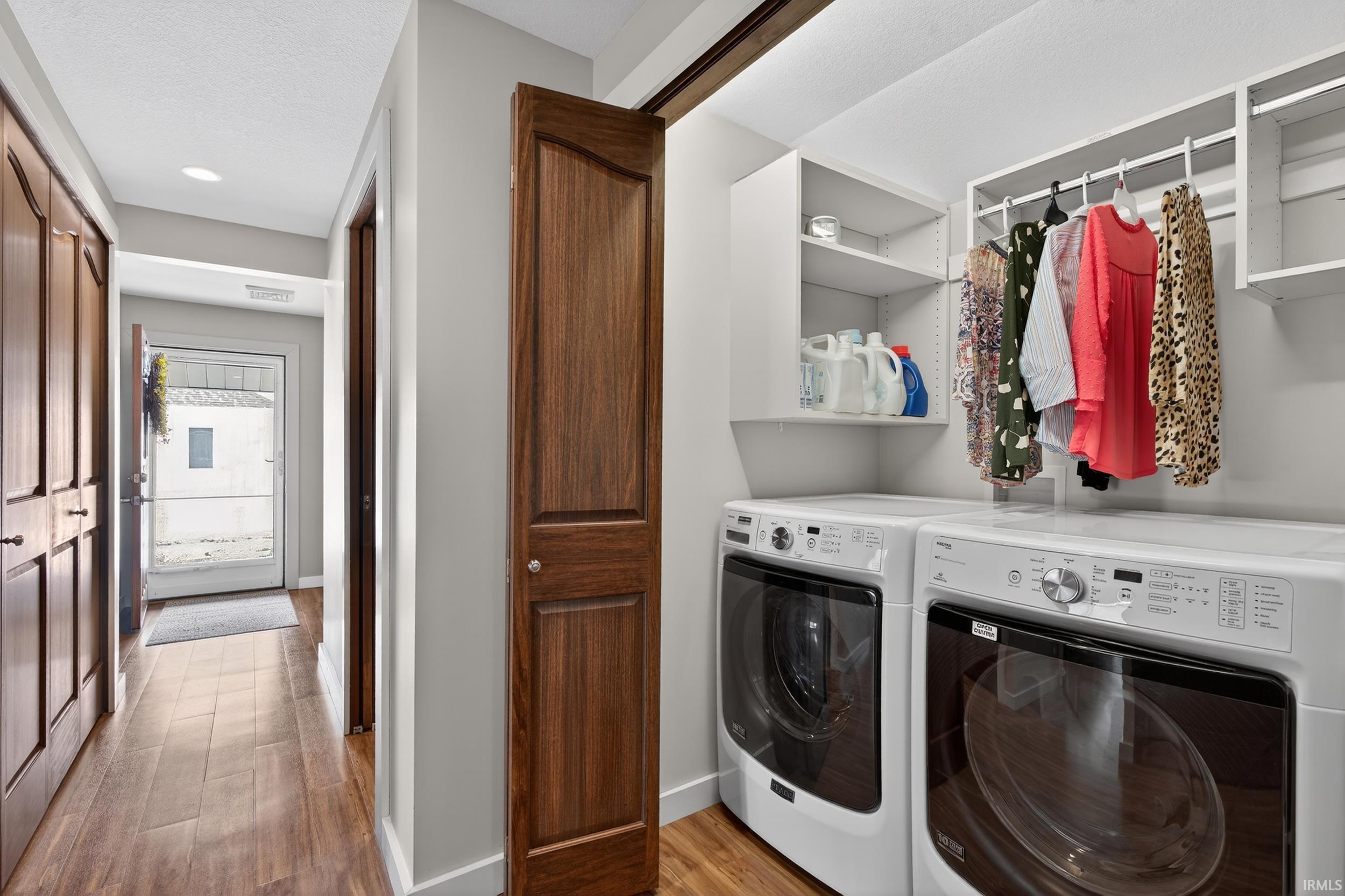 Laundry area featuring light wood-type flooring, washing machine and dryer, and recessed lighting