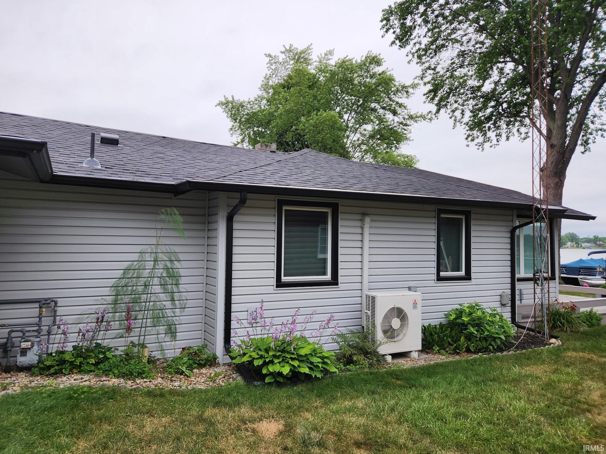 View of home's exterior featuring roof with shingles and a yard