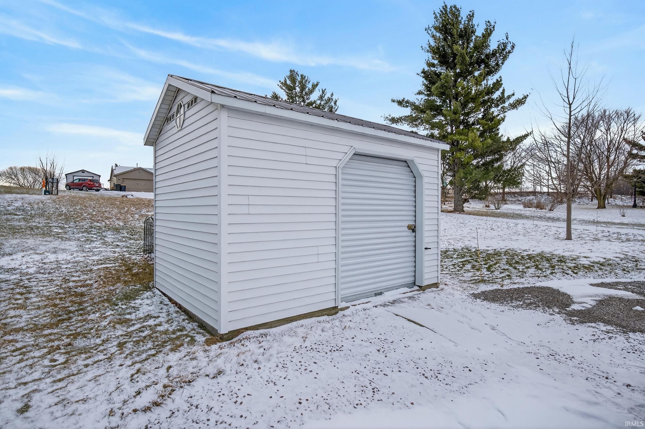 Snow covered structure featuring a storage unit