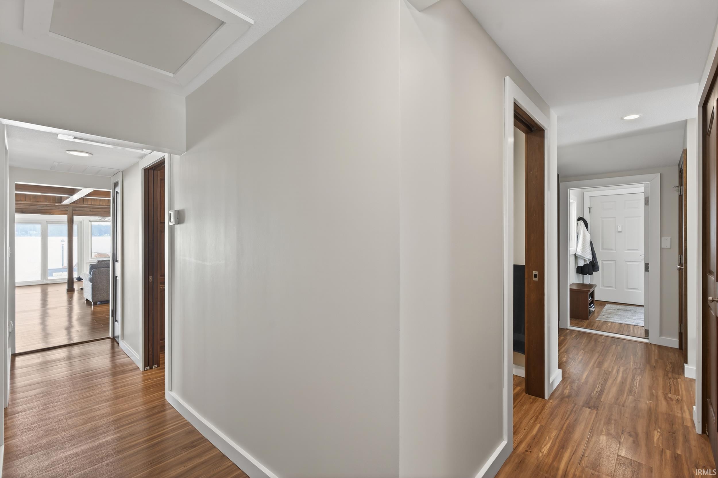 Corridor with dark wood-style flooring and recessed lighting