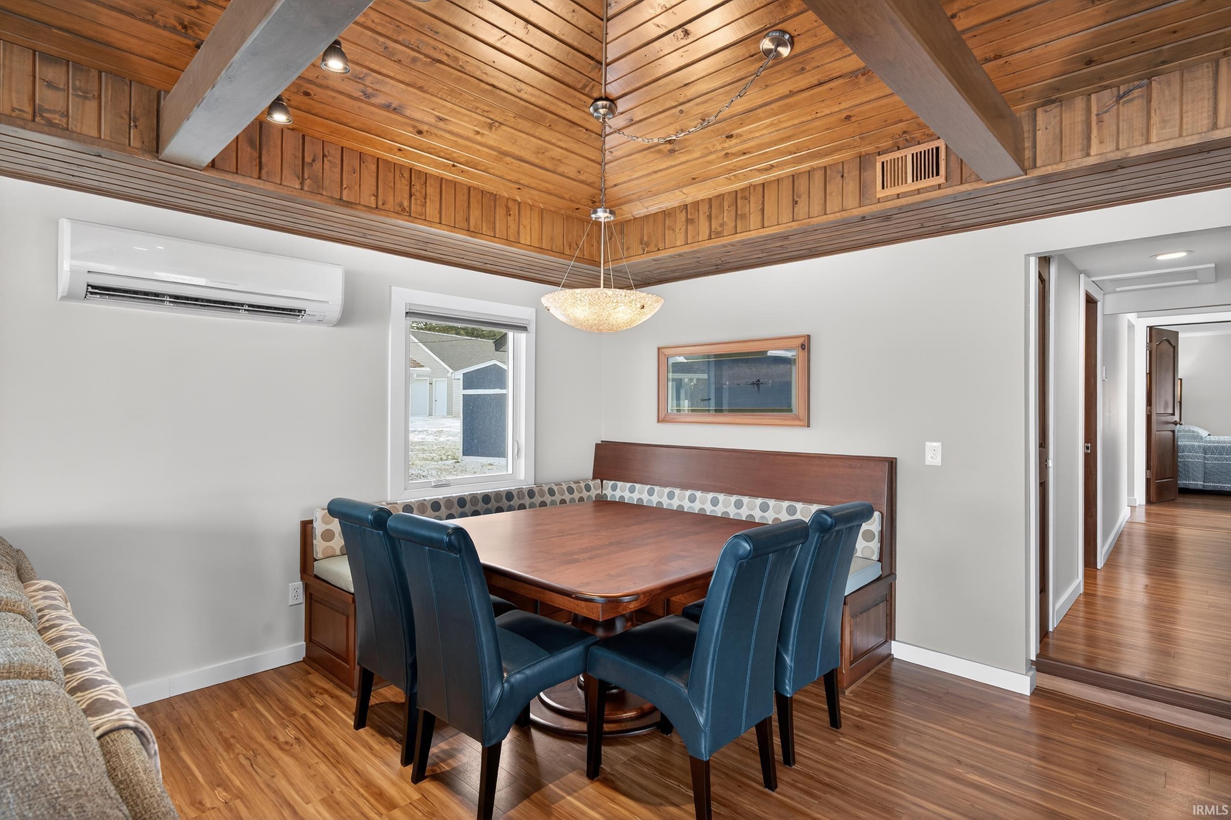 Dining space with a wooden ceiling with exposed beams and wood finished floors