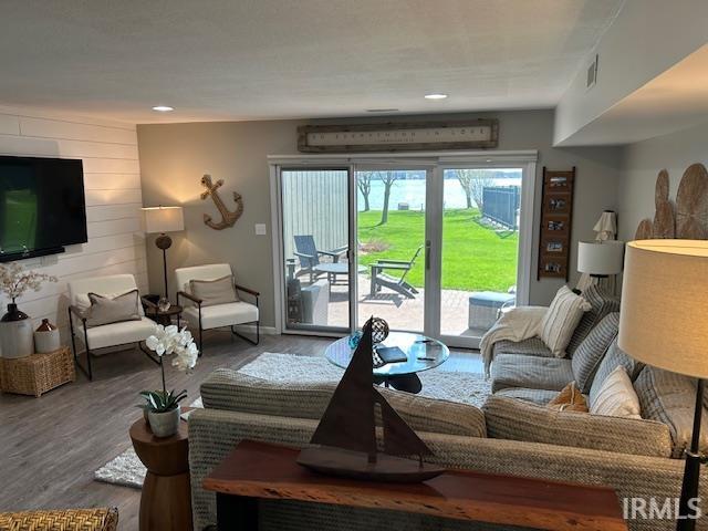 Living room featuring wood finished floors, wood walls, and recessed lighting