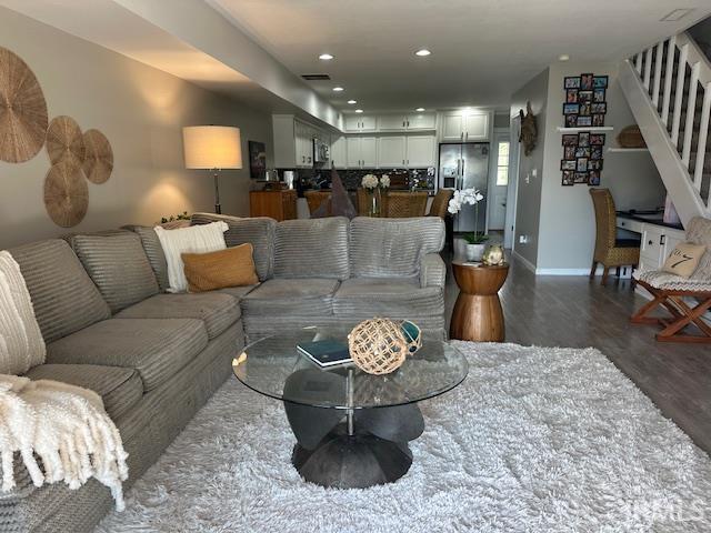 Living room with recessed lighting and dark wood-style flooring