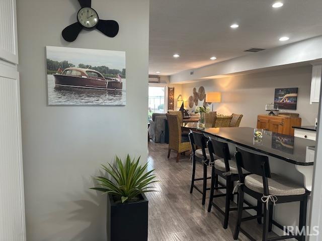 Bar area with recessed lighting, dark wood-type flooring, dark countertops, and a ceiling fan