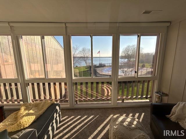 Sunroom / solarium with a water view and carpet