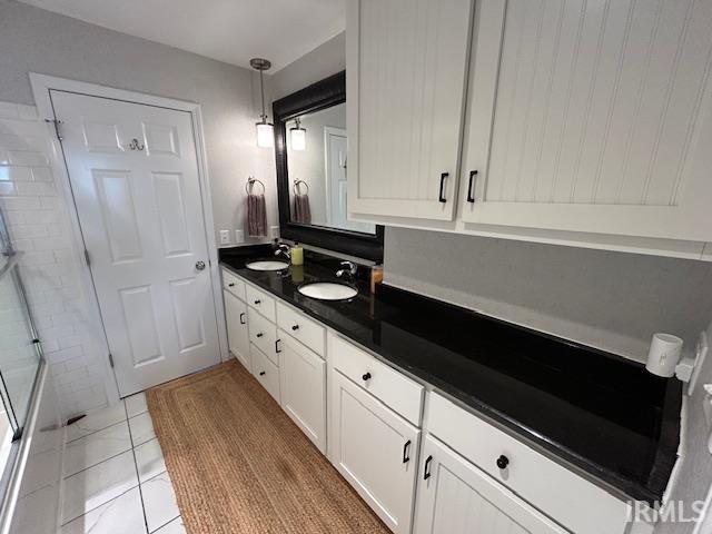 Full bathroom with double vanity and light tile patterned floors