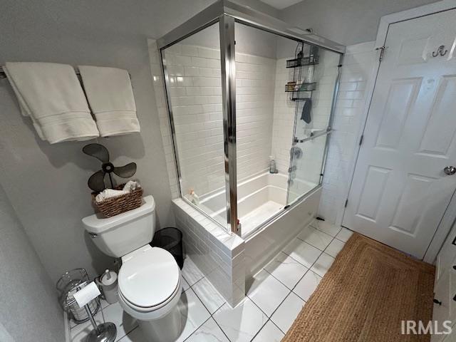 Bathroom featuring combined bath / shower with glass door and light tile patterned floors