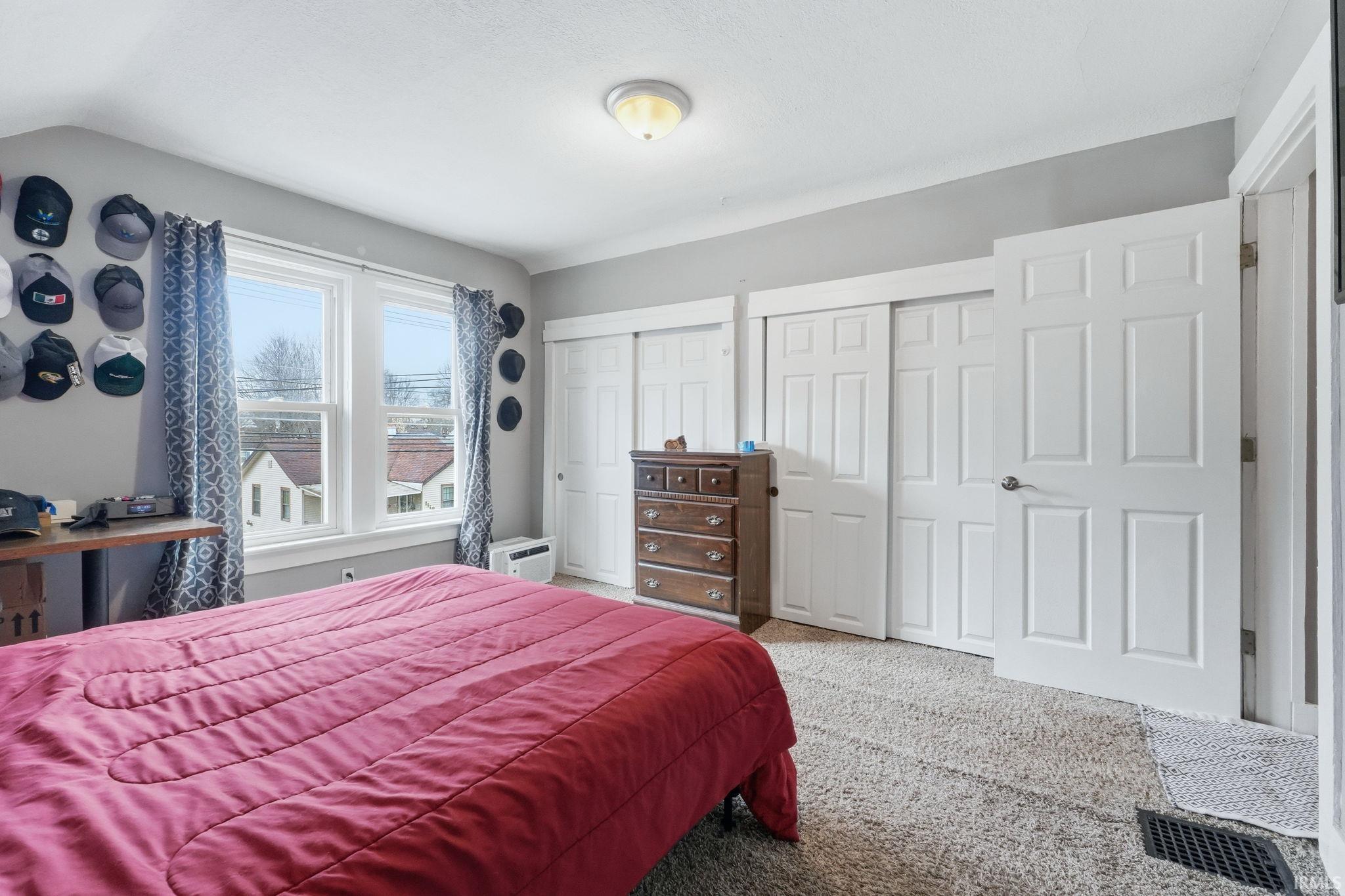 Bedroom featuring two closets and carpet flooring