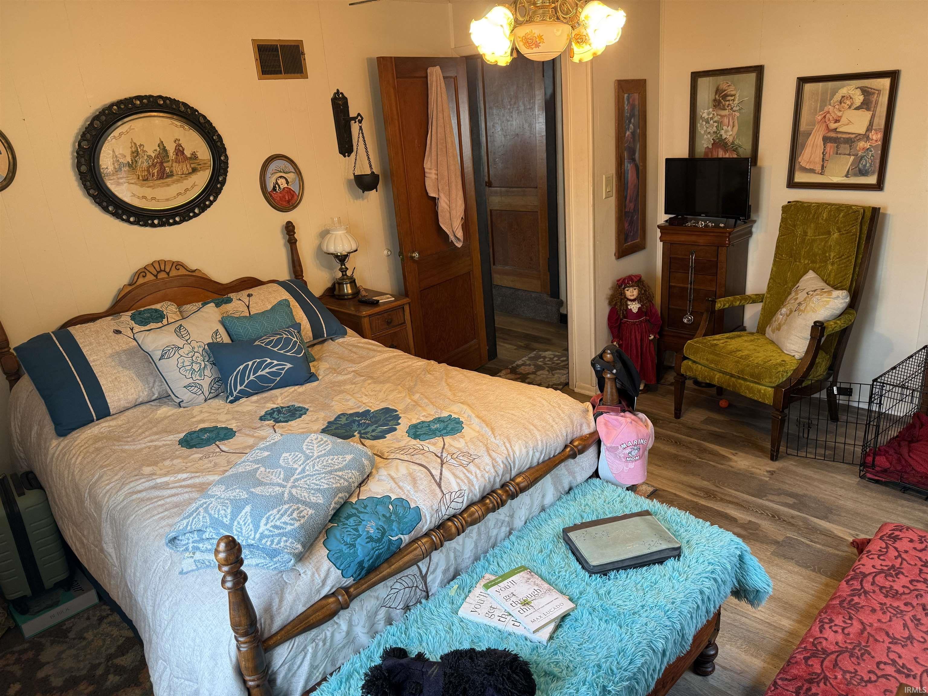Bedroom featuring dark wood-style floors and a chandelier