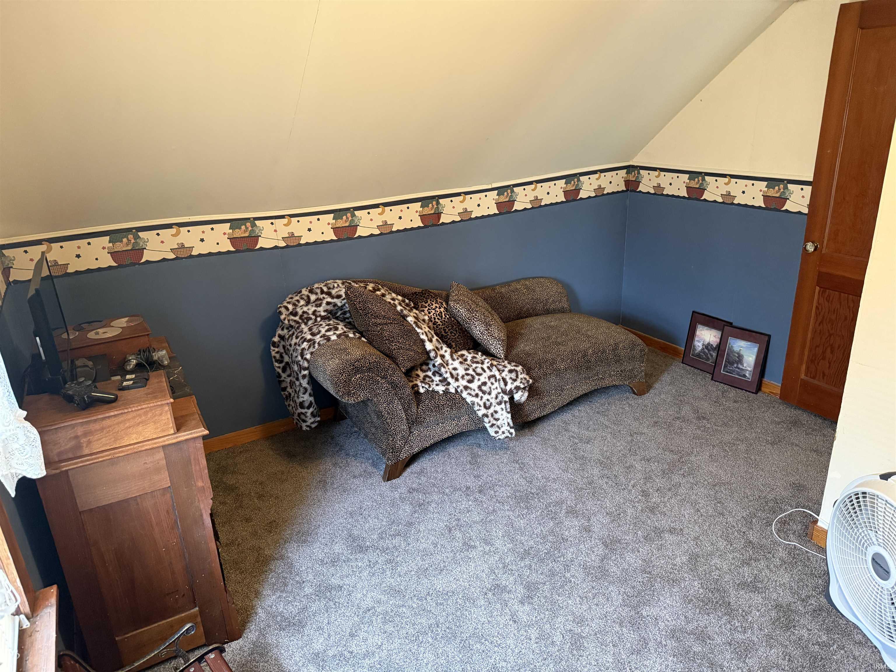 Carpeted living area with lofted ceiling and baseboards