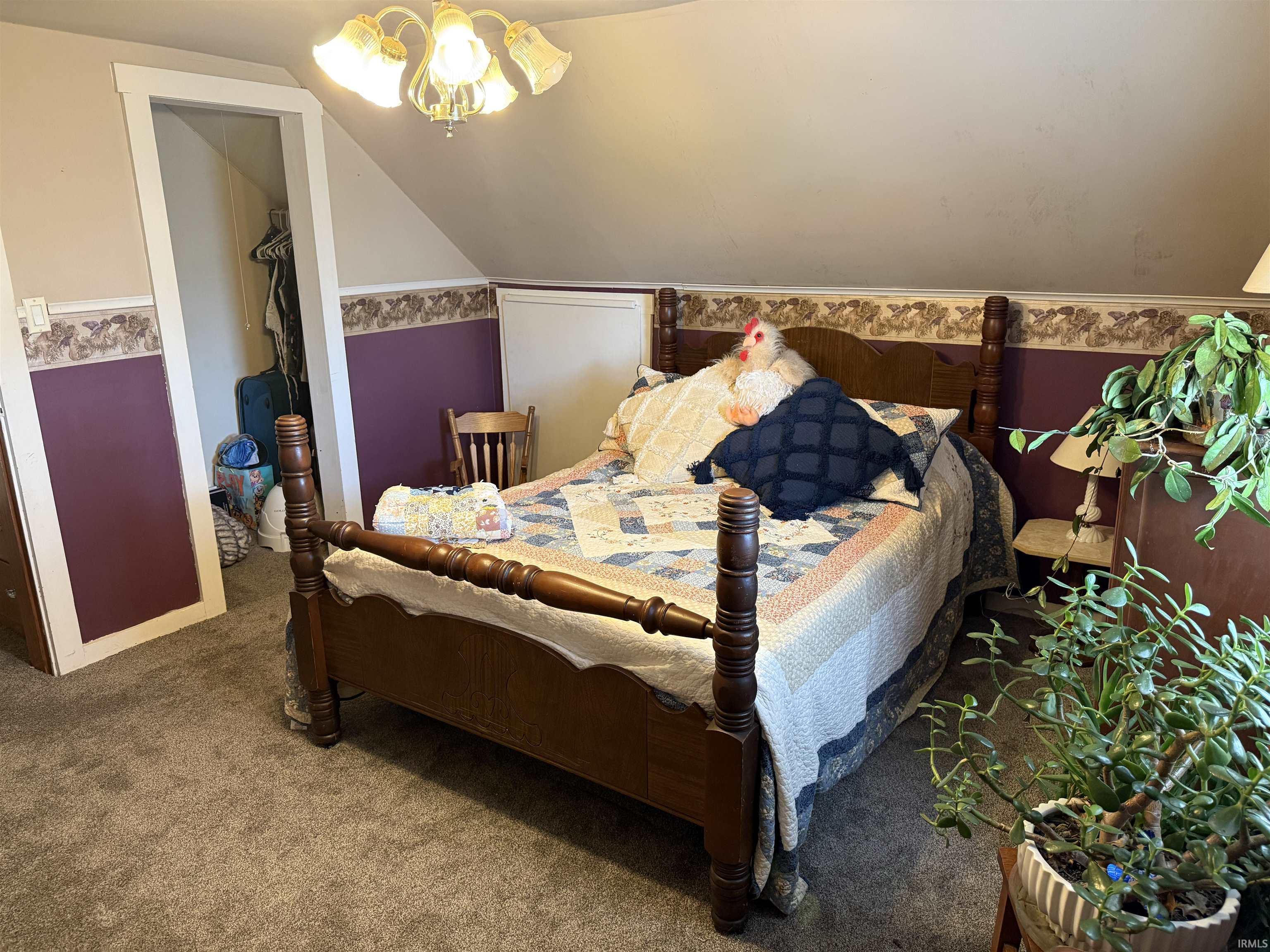 Carpeted bedroom with a spacious closet, lofted ceiling, and ceiling fan