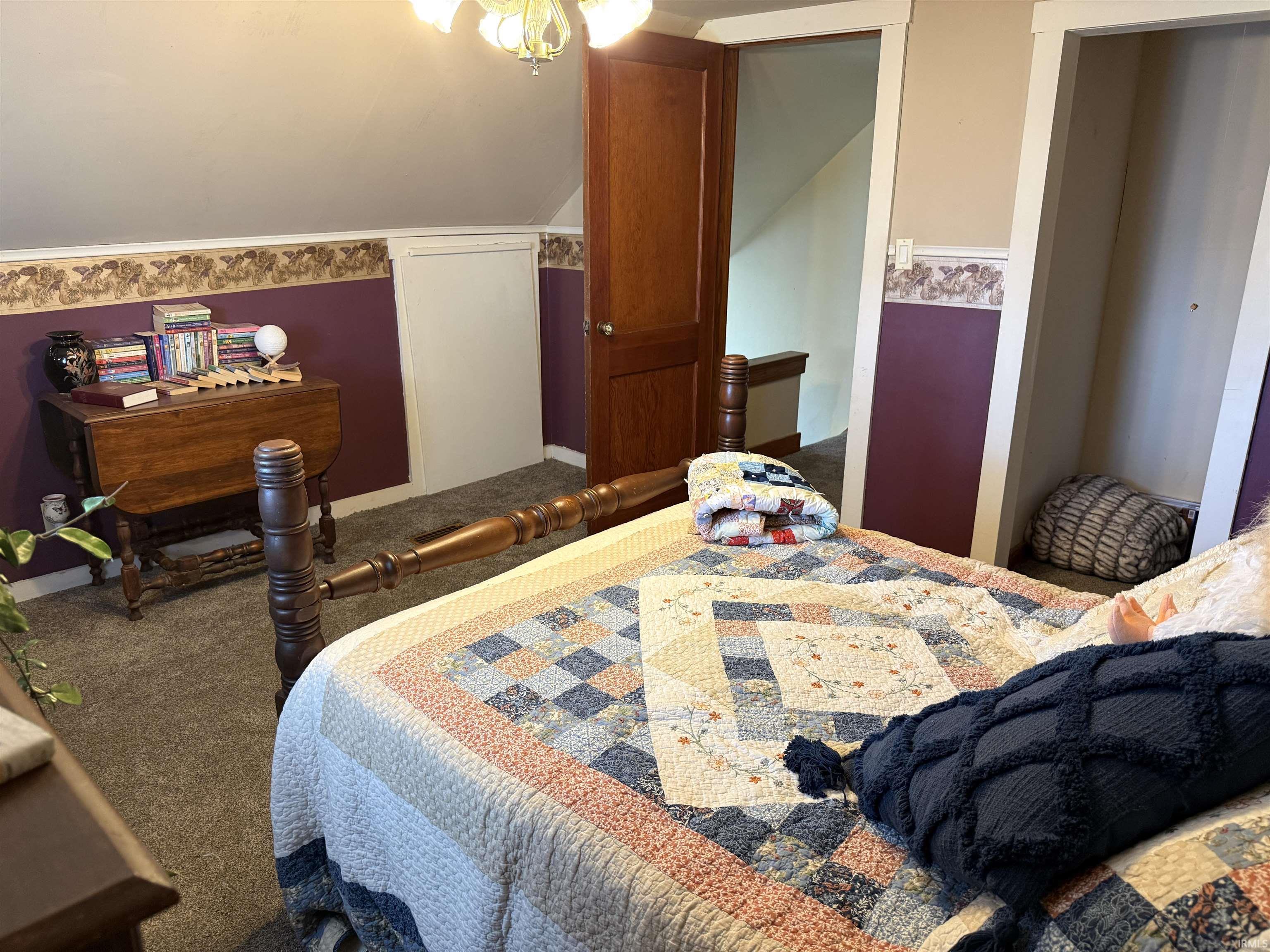 Carpeted bedroom featuring lofted ceiling
